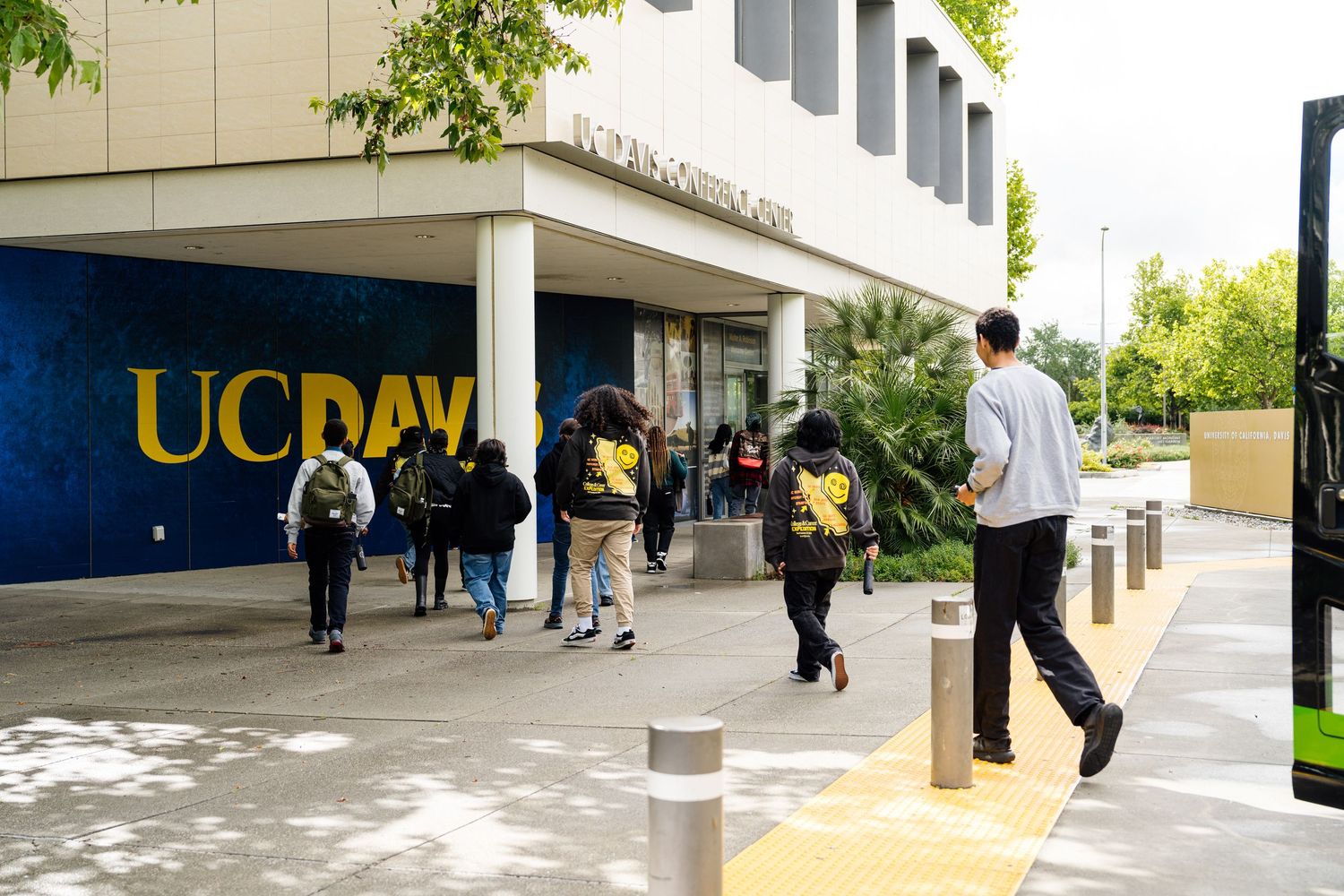Students walking outside the UC Davis student union building on a sunny day.