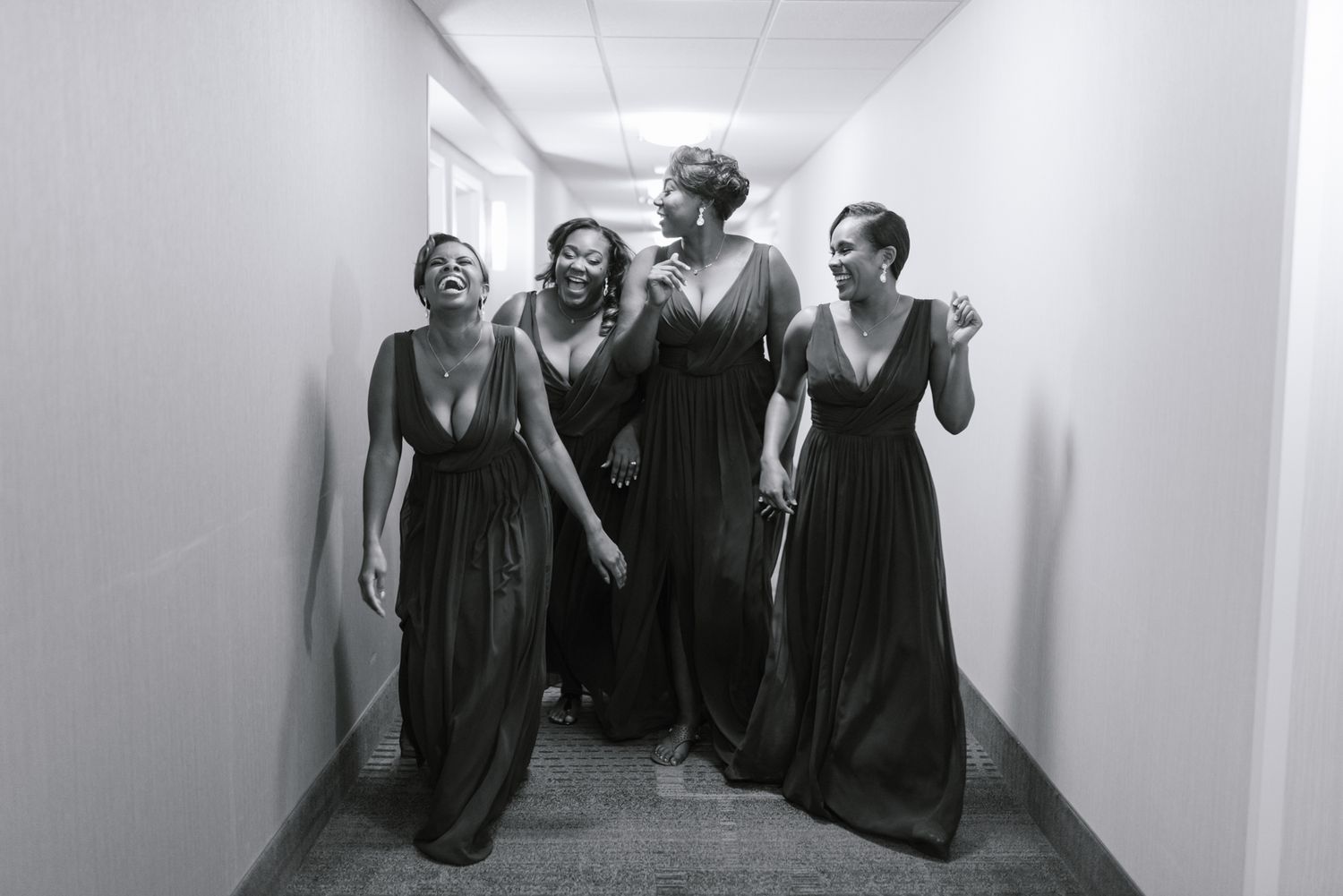 A group performs in a white hallway creating dramatic silhouettes against the walls.
