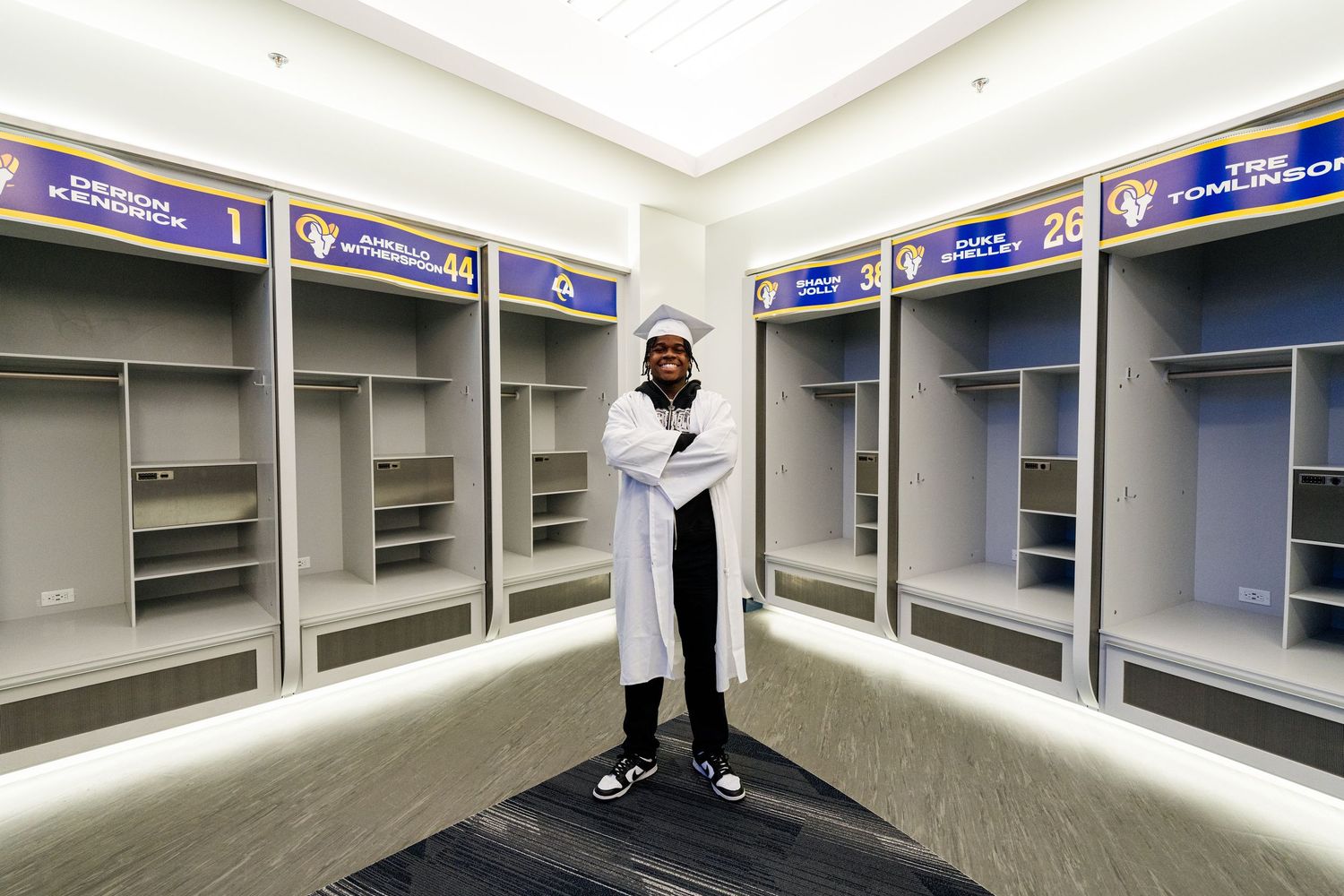 Modern locker room interior with blue and gray lockers and bright lighting.