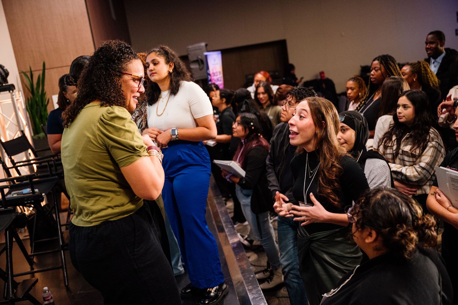 Diverse group of people engaged in animated conversation at a networking event.