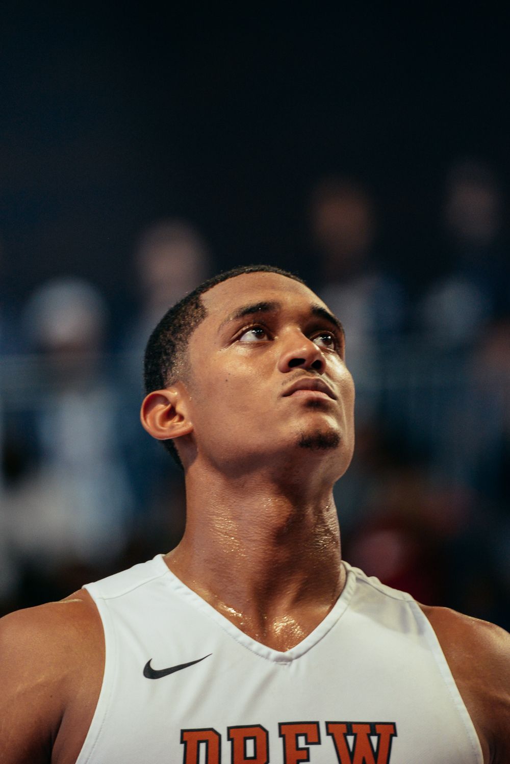 Basketball player in white jersey focused during an intense game moment.