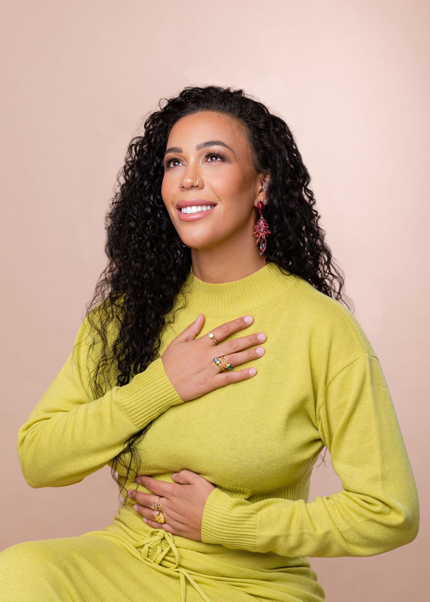 A person in a bright yellow sweater poses expressively against a beige background in a series of connected photos.