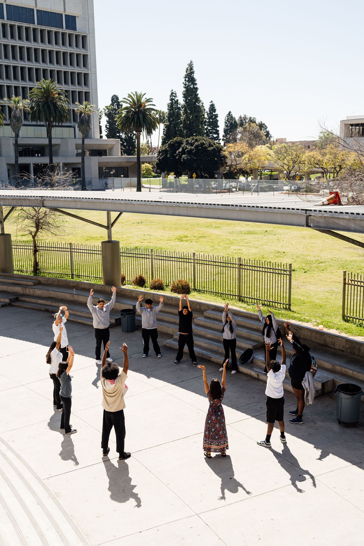 Group of people exercising outdoors in front of a modern building.