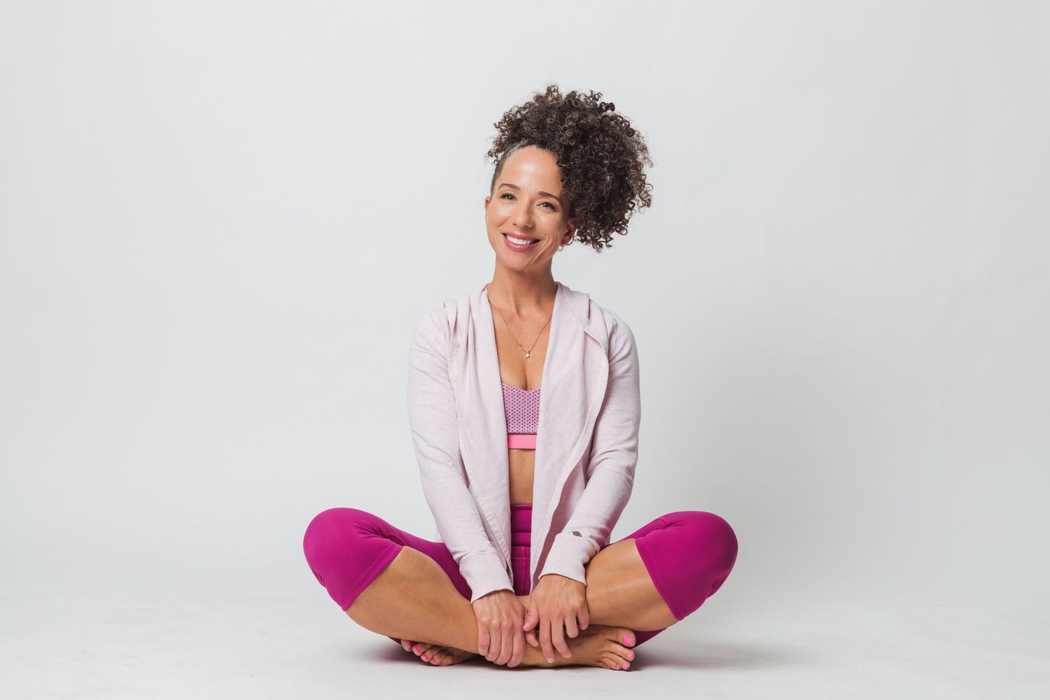 Athletic wear fashion shoot with pink and white studio backdrop.