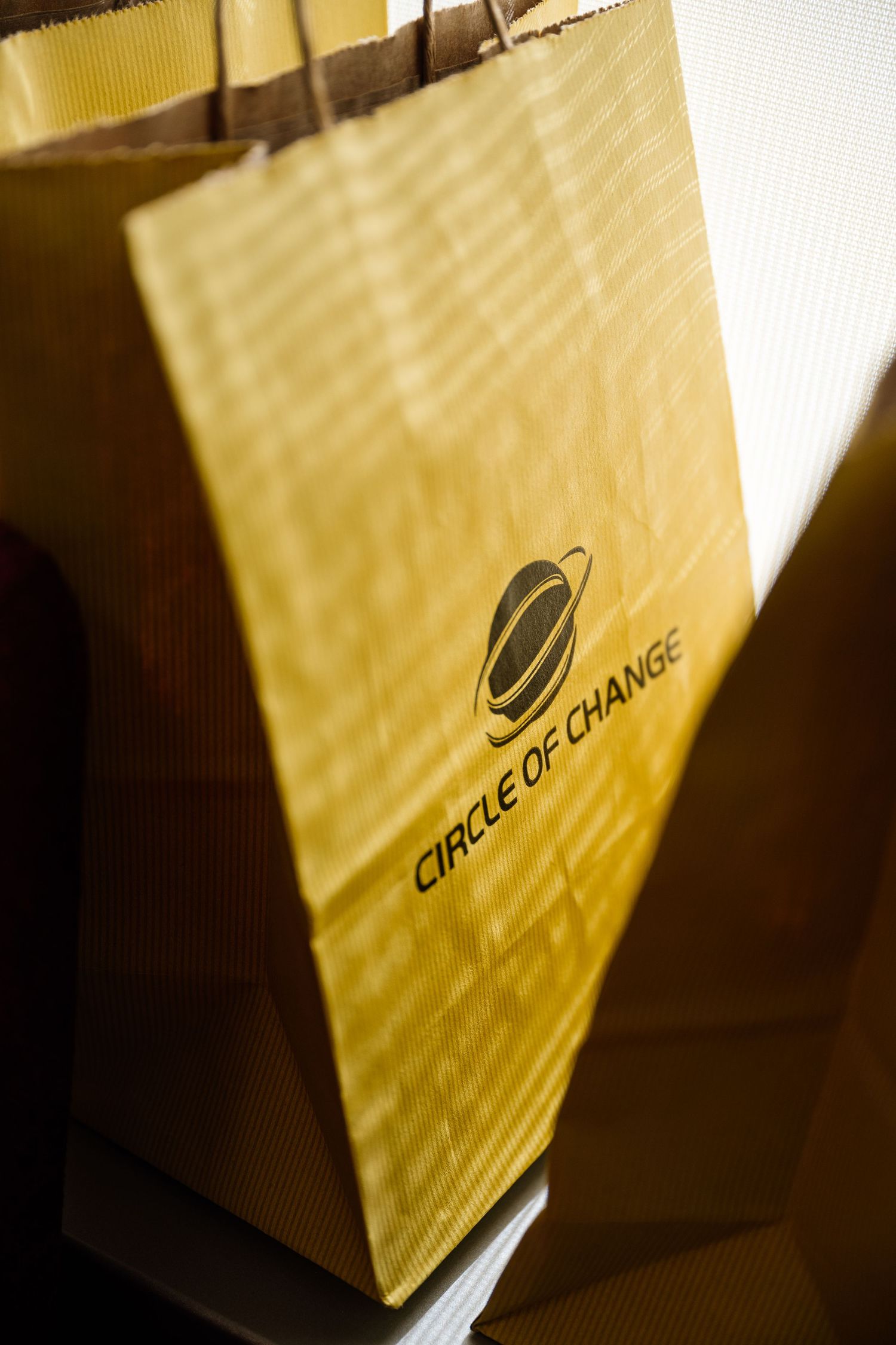 Close-up of a yellow Circle of Change branded paper shopping bag.
