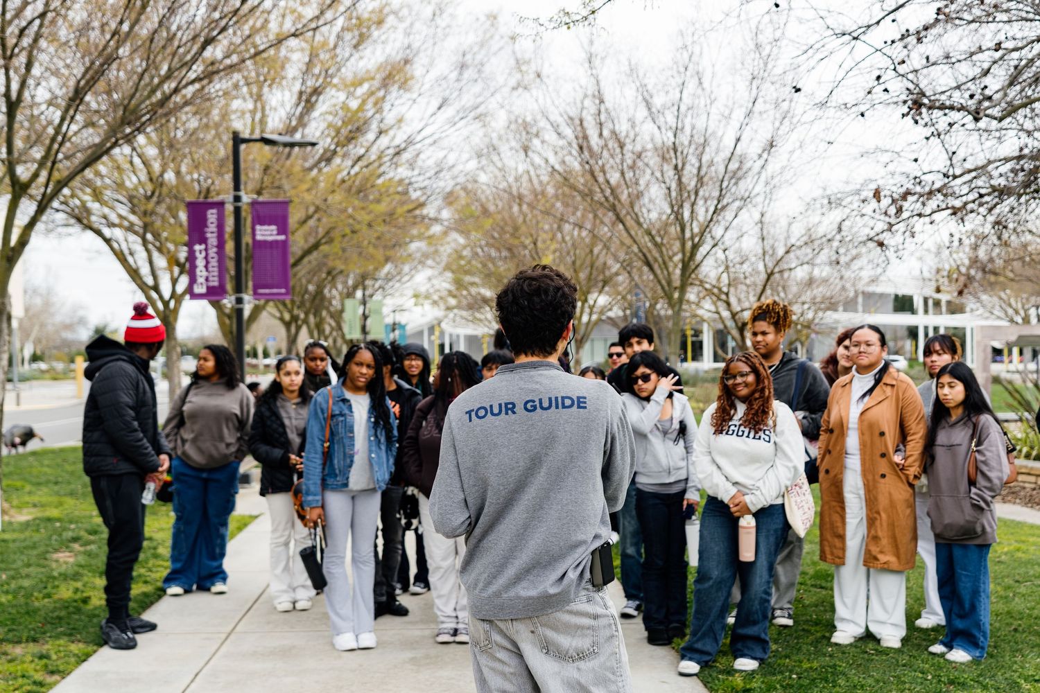 Line of people gathered outdoors near trees during a group event.