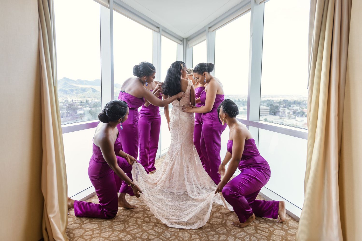 Wedding preparation scene with bridesmaids in purple dresses helping with the bride's gown.