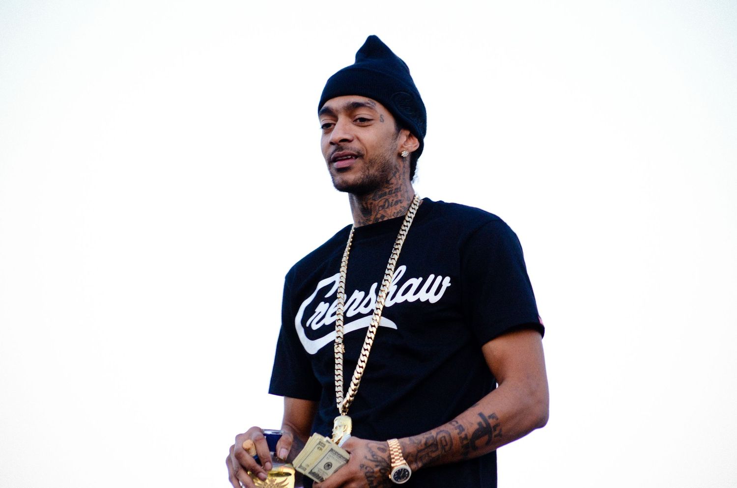 Person in casual streetwear and beanie posing against white background.