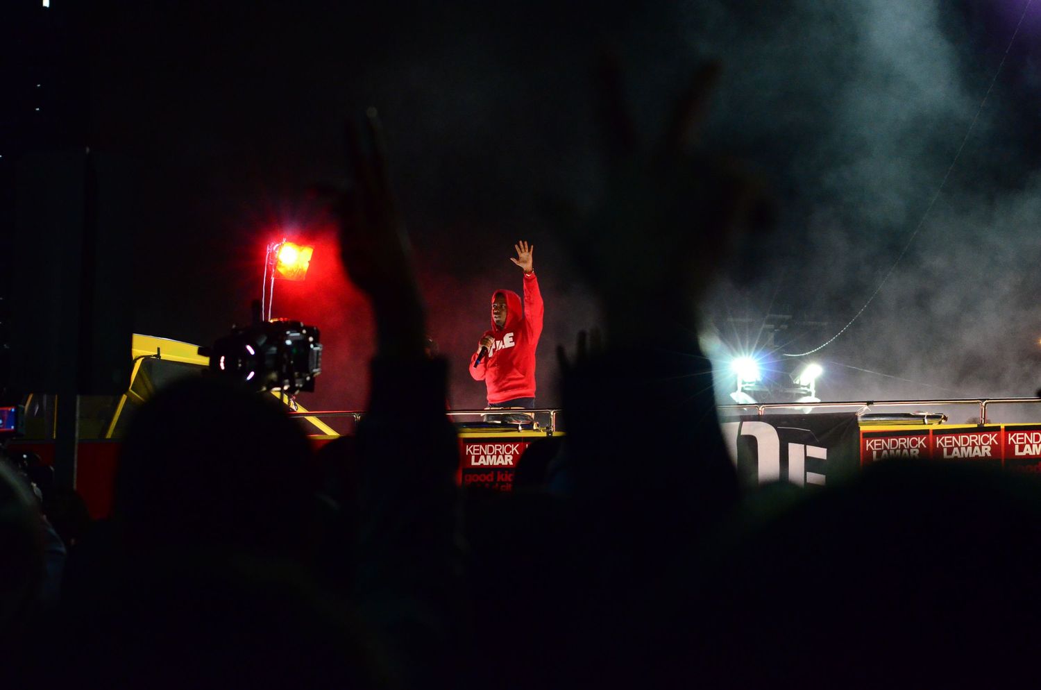 Dark concert stage with red lights and smoke effects creating an atmospheric performance environment.