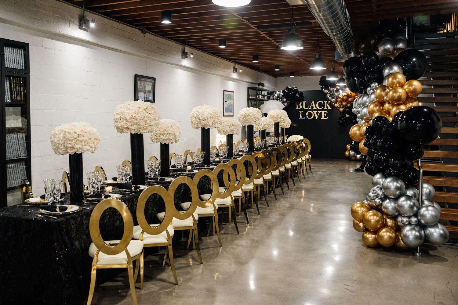 Elegant event space with gold chairs and balloon decorations arranged in rows.
