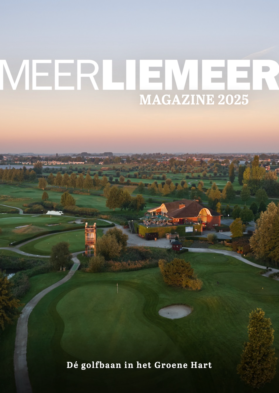 Aerial drone view of a scenic golf course with winding paths and clubhouse during golden sunset hour.