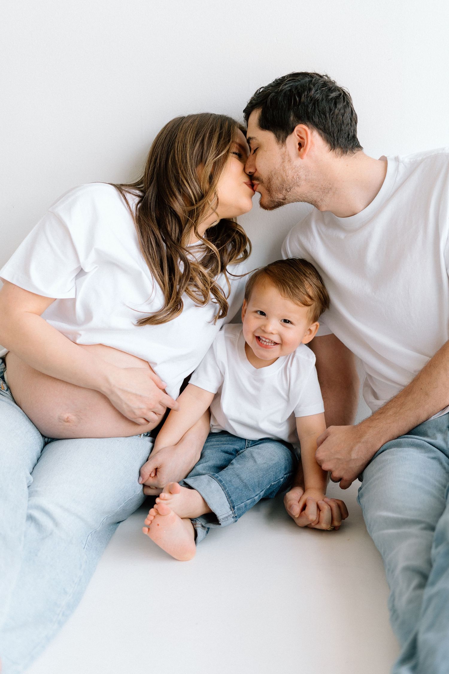 Candid family photo sequence showing parents and child playing together on white background.