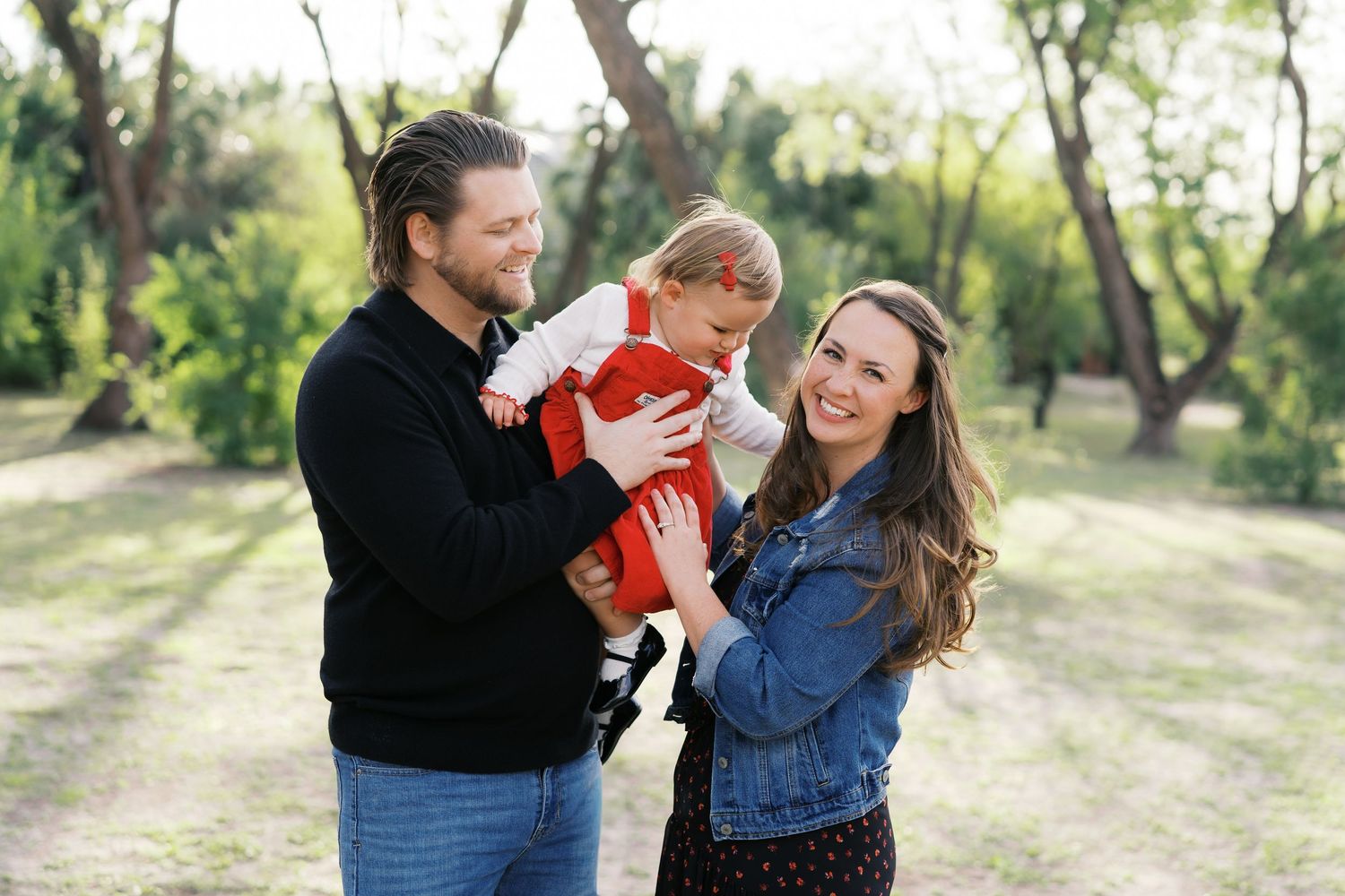 Family enjoying a candid moment together in a sunlit outdoor setting.