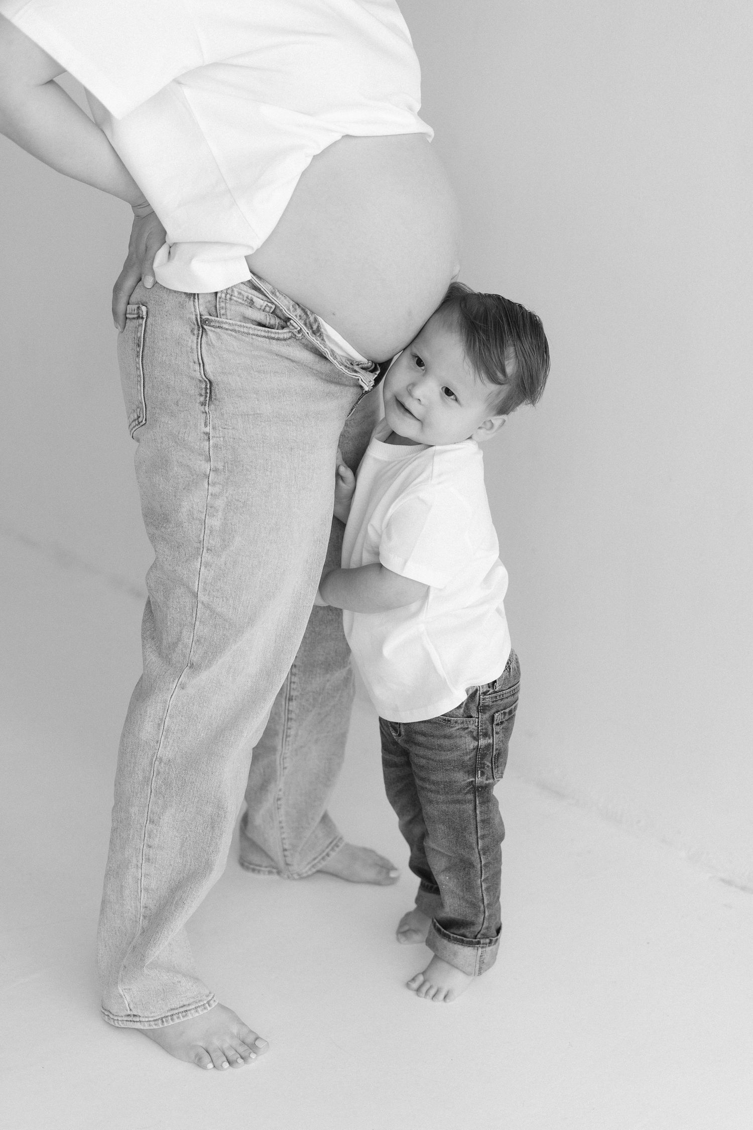 Black and white series showing child and adult legs in denim against white background.