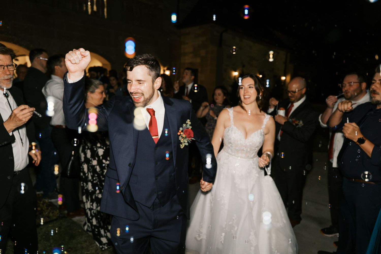 Newlyweds make their grand exit while guests celebrate with sparklers outside.