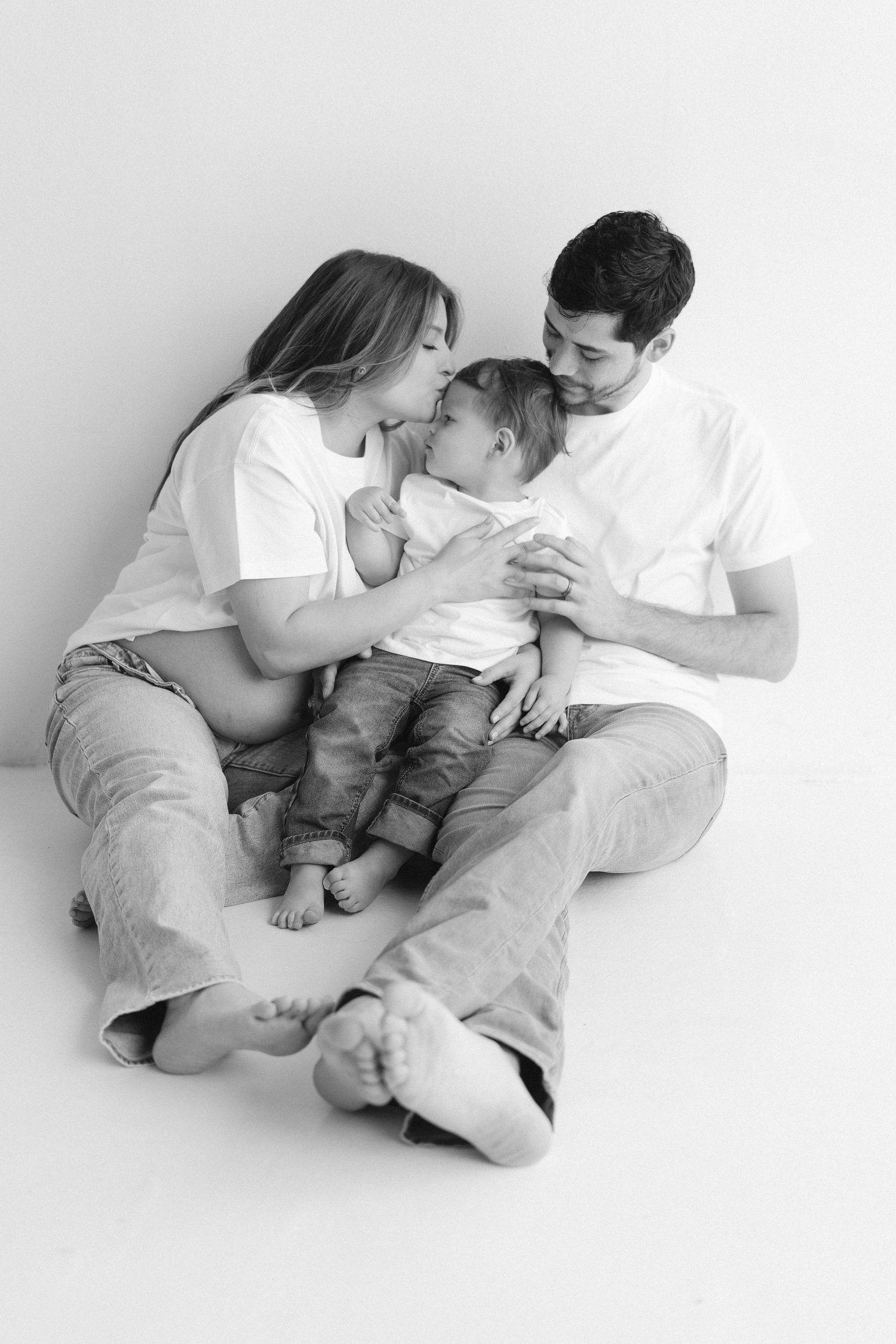 Minimalist black and white family portrait series showing intimate moments on white background.
