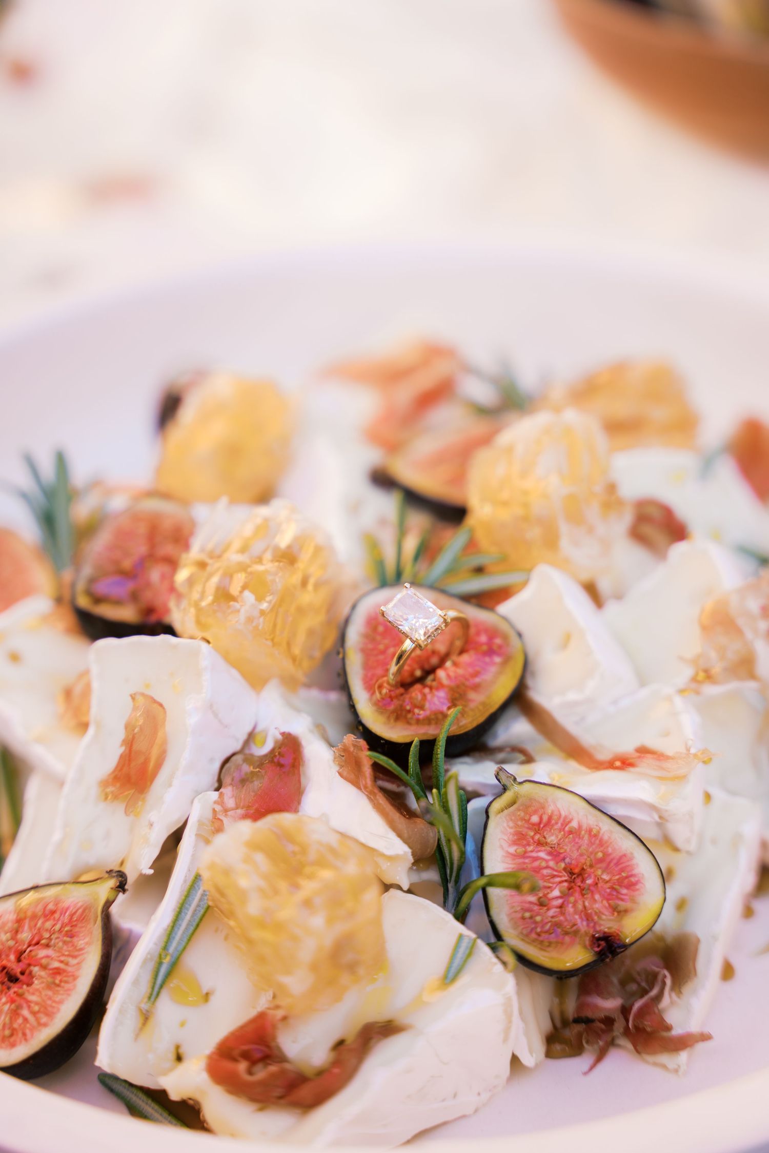 Elegant appetizer plate with fresh figs and cheese garnished with herbs.