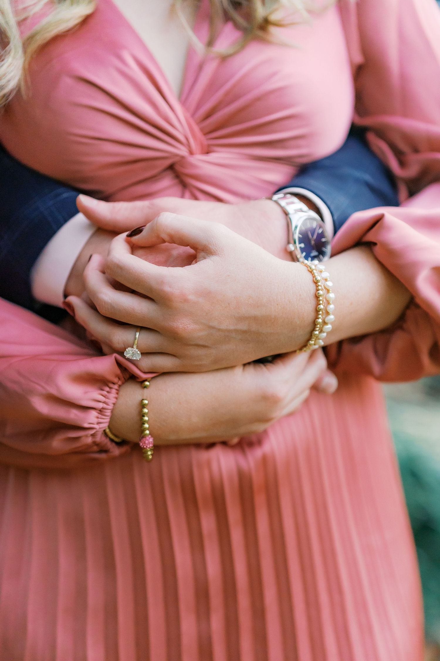 Close-up shots of hands showing engagement ring and jewelry details against a pink pleated dress.