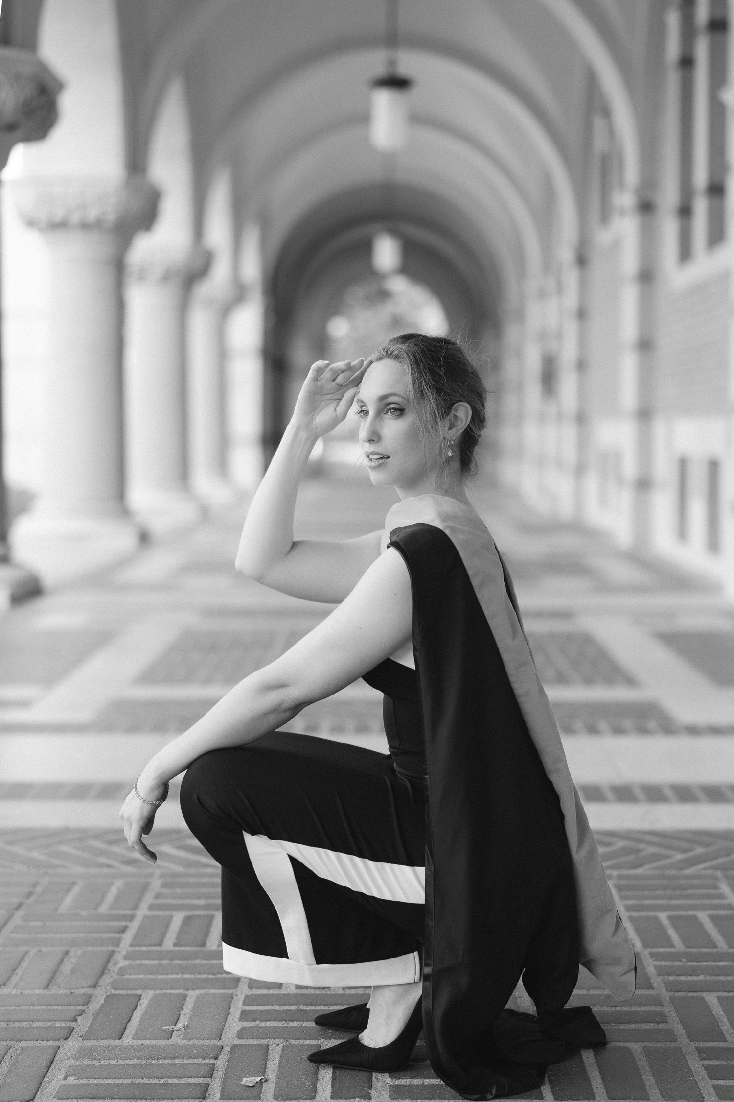 Black and white portraits captured in an elegant columned hallway with dramatic lighting.