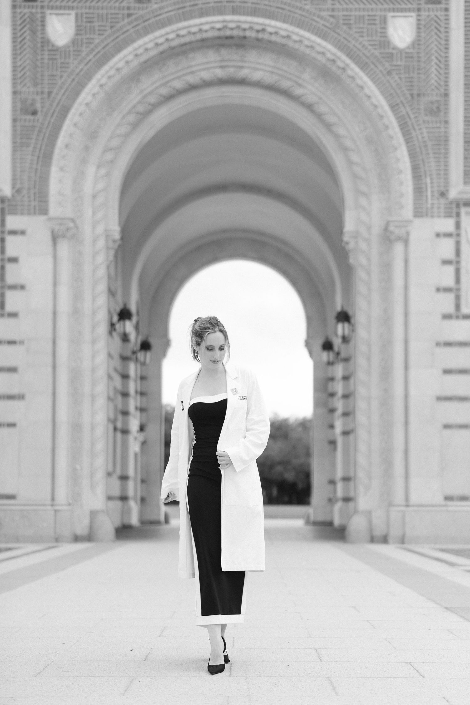 A series of elegant archways in a classical architectural corridor with white stone columns and brick accents.