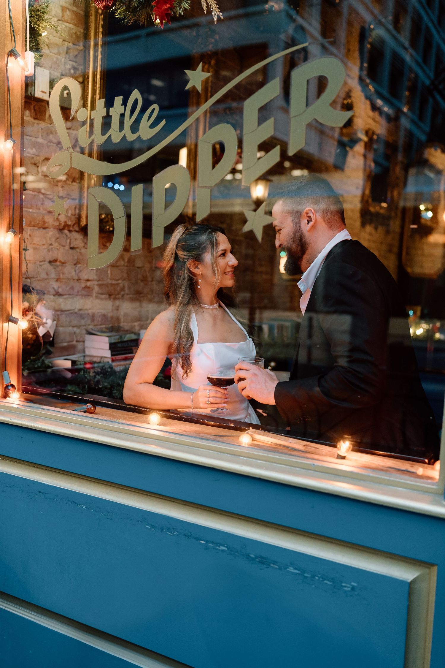 A series of candlelit window scenes at a brick building storefront.