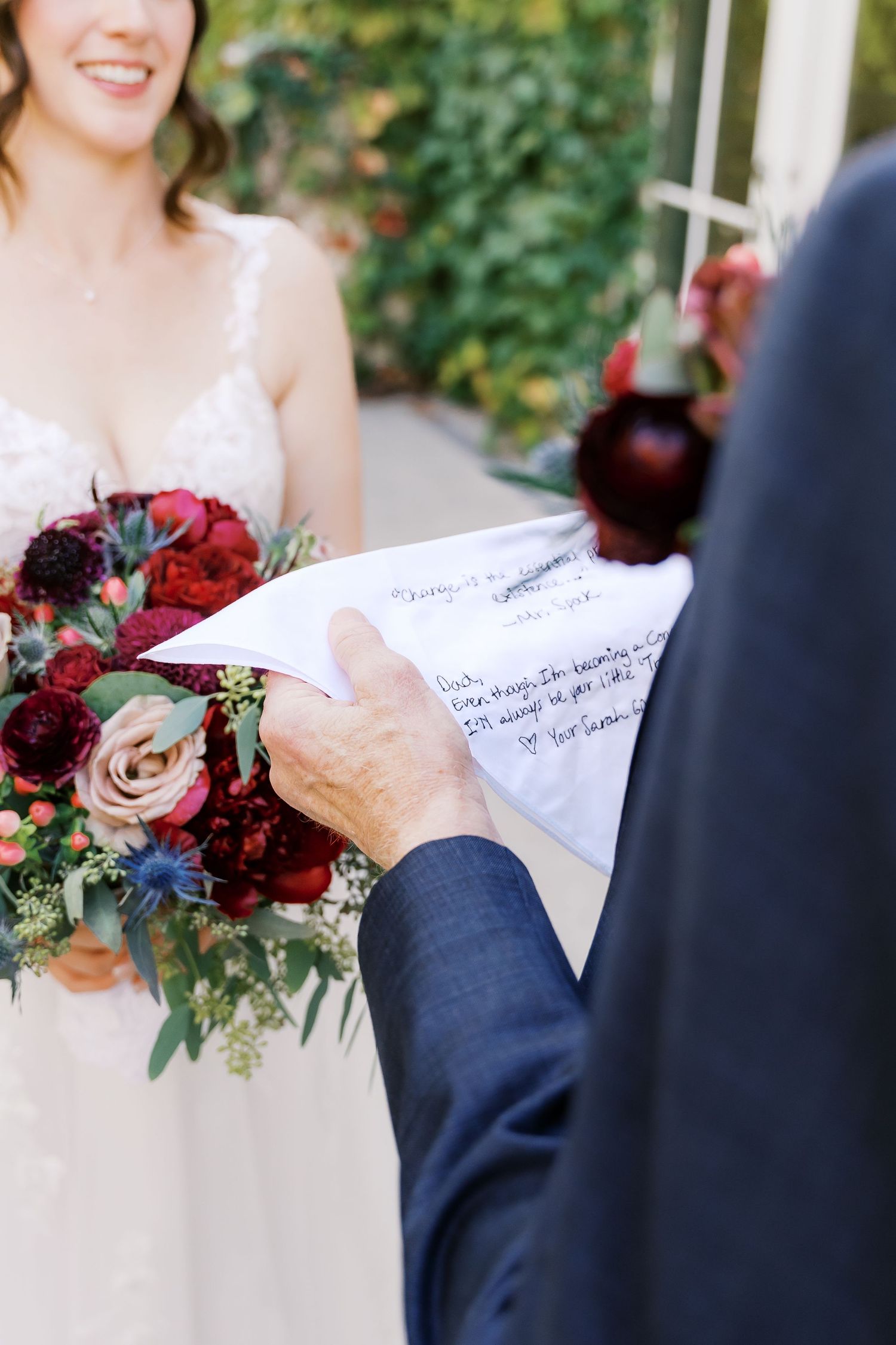 Close-up of handwritten wedding letter being read during outdoor ceremony.