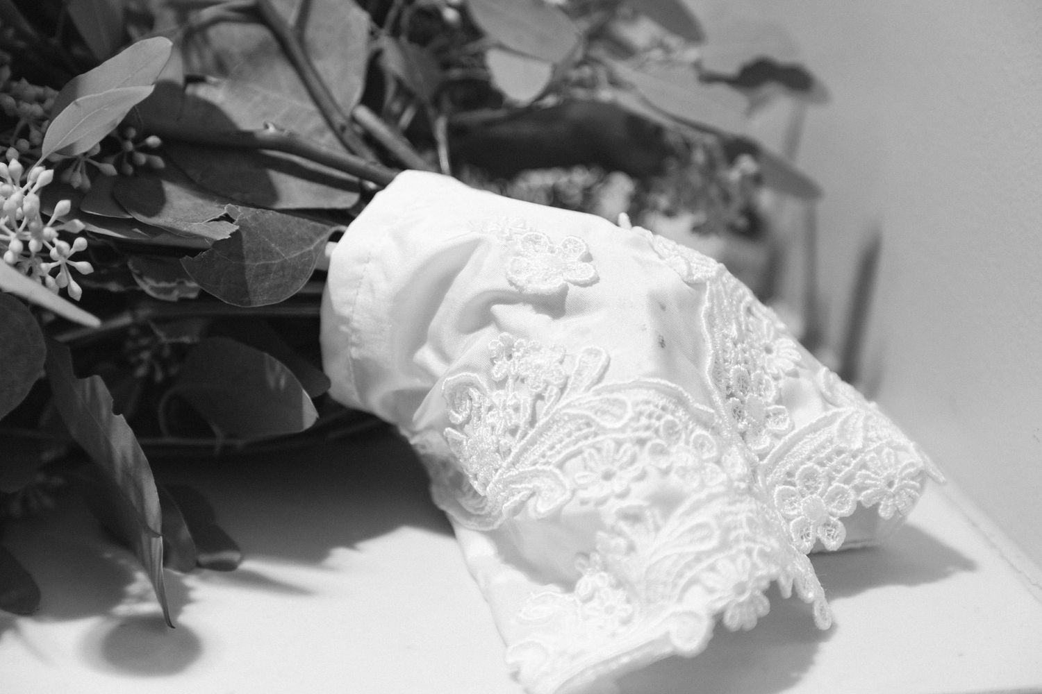 Delicate white lace wedding dress details in black and white.