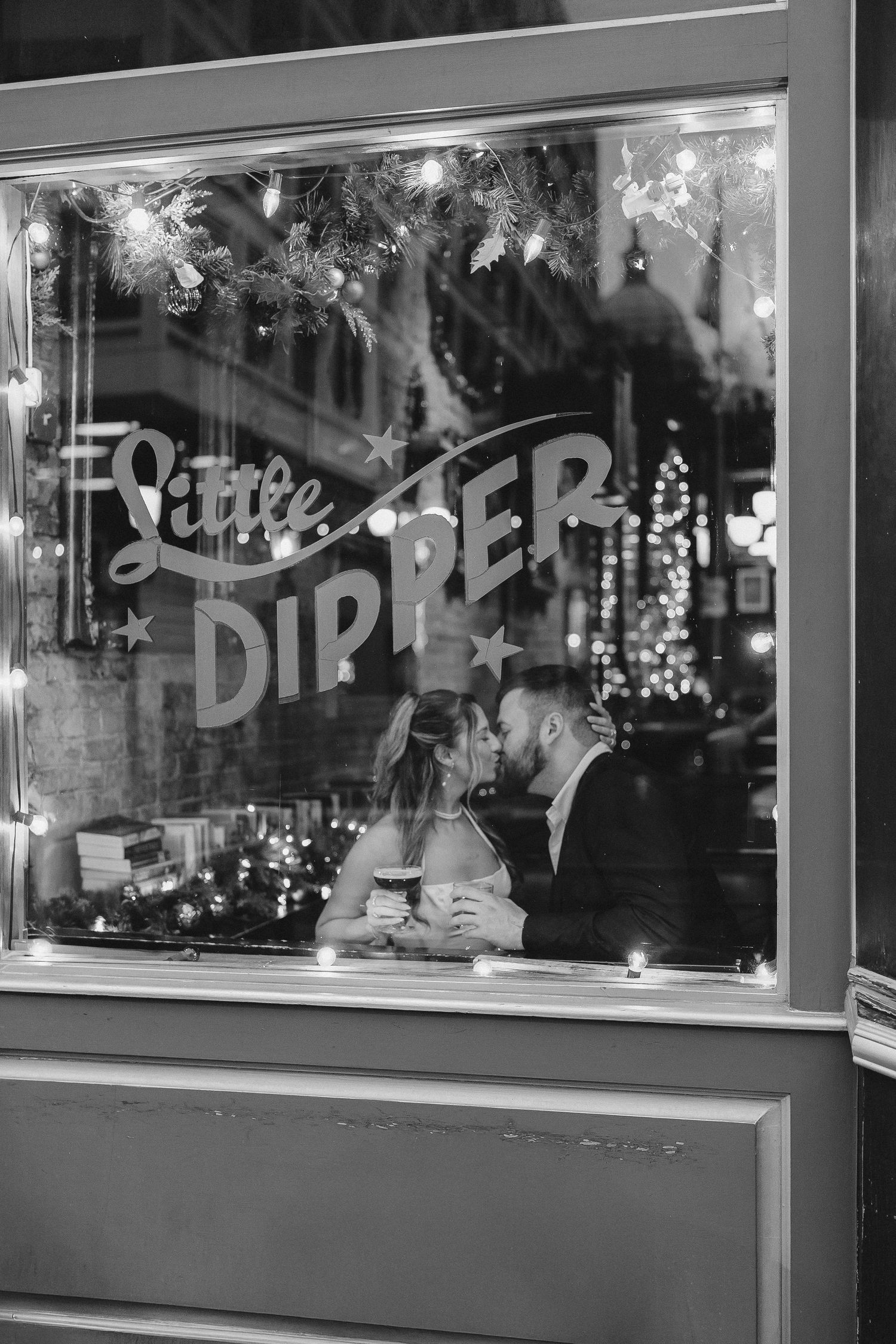 A storefront window display at night with illuminated signage and reflections.
