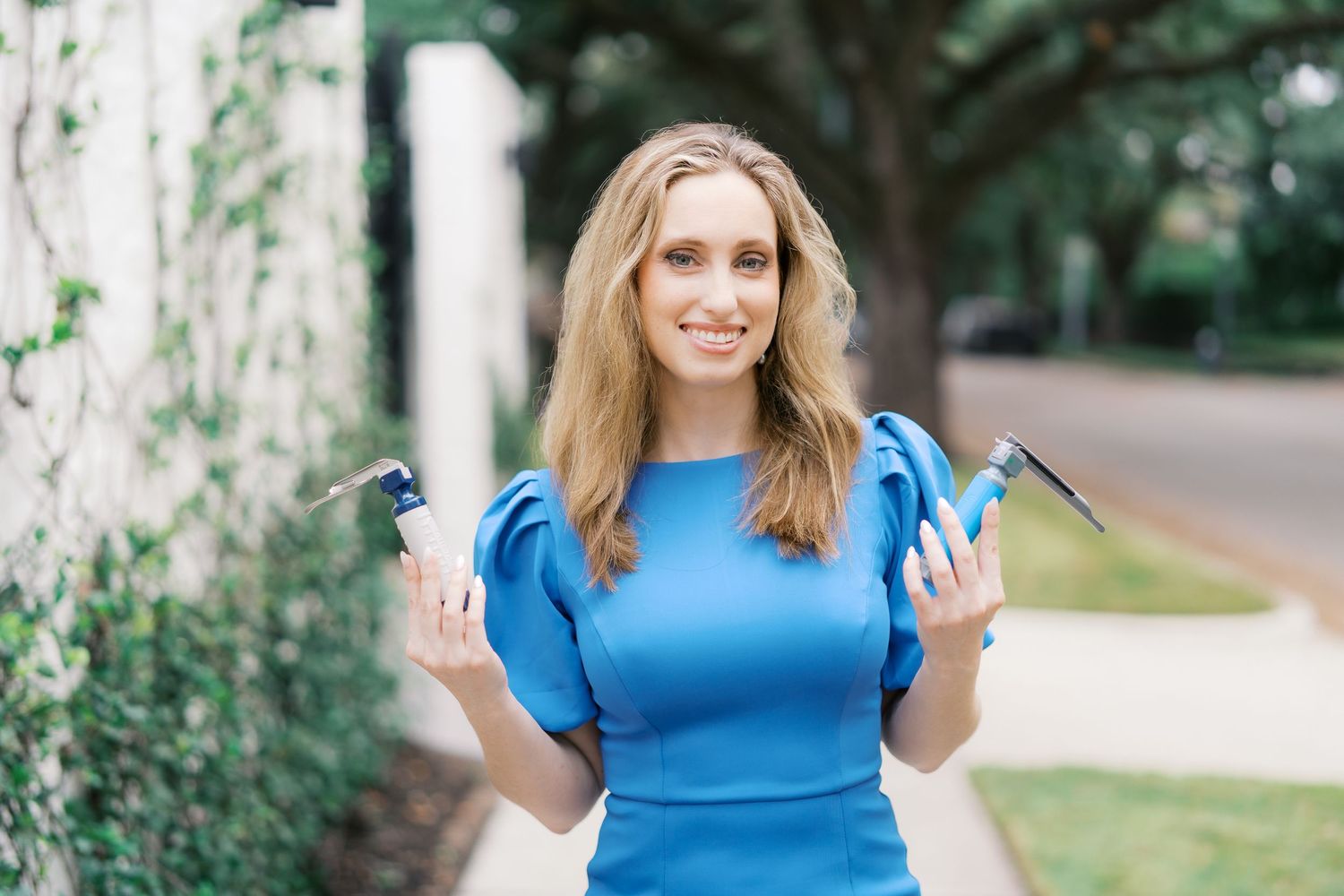 Joyful movement captured in flowing blue dress against outdoor setting.