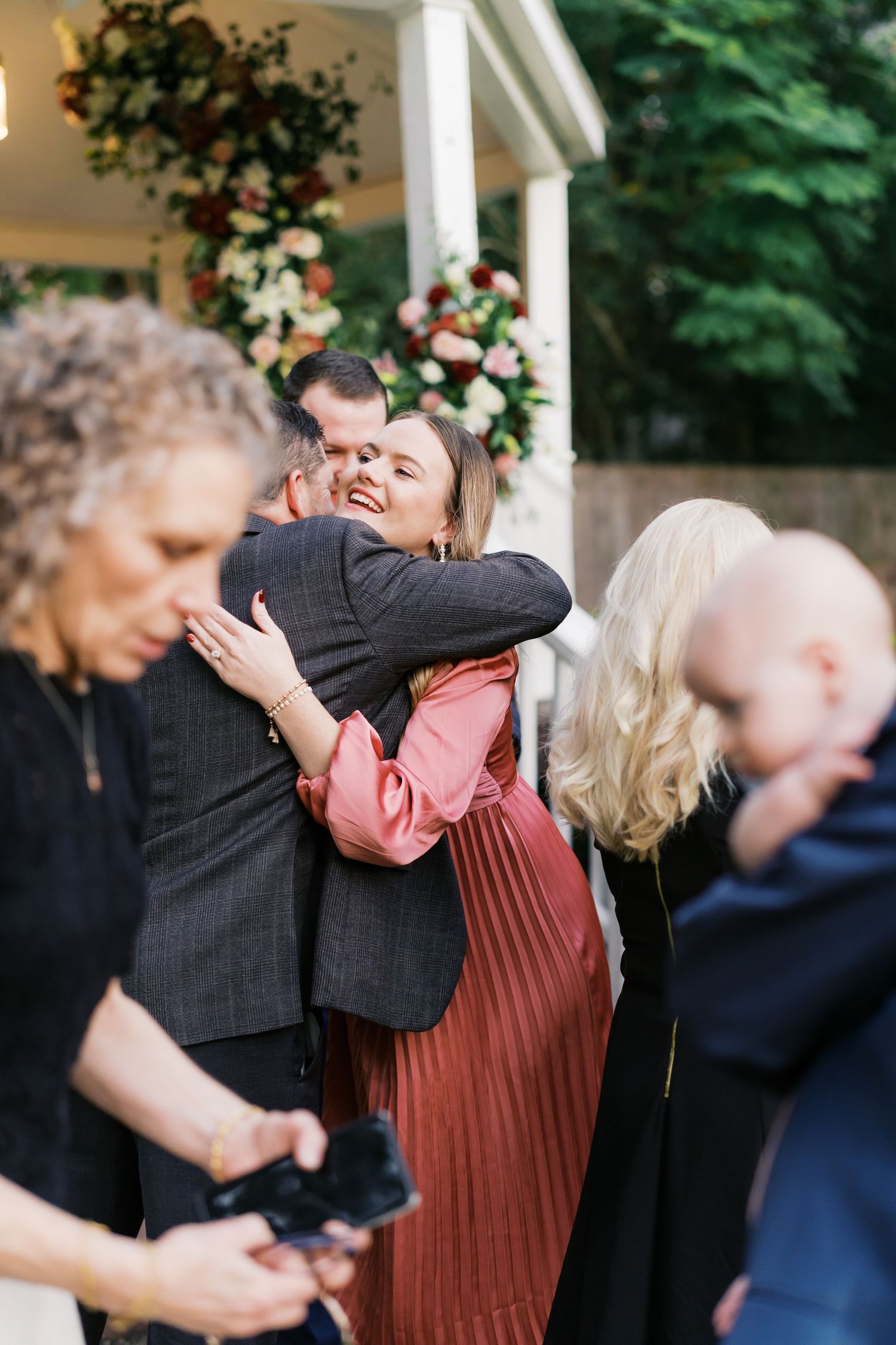 Couple sharing a joyful moment during a surprise proposal at a garden gazebo.