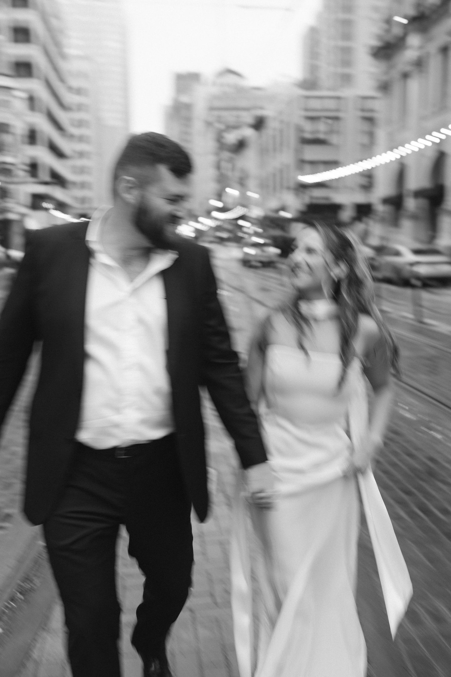 Motion blur photo of couple walking on wet city street.