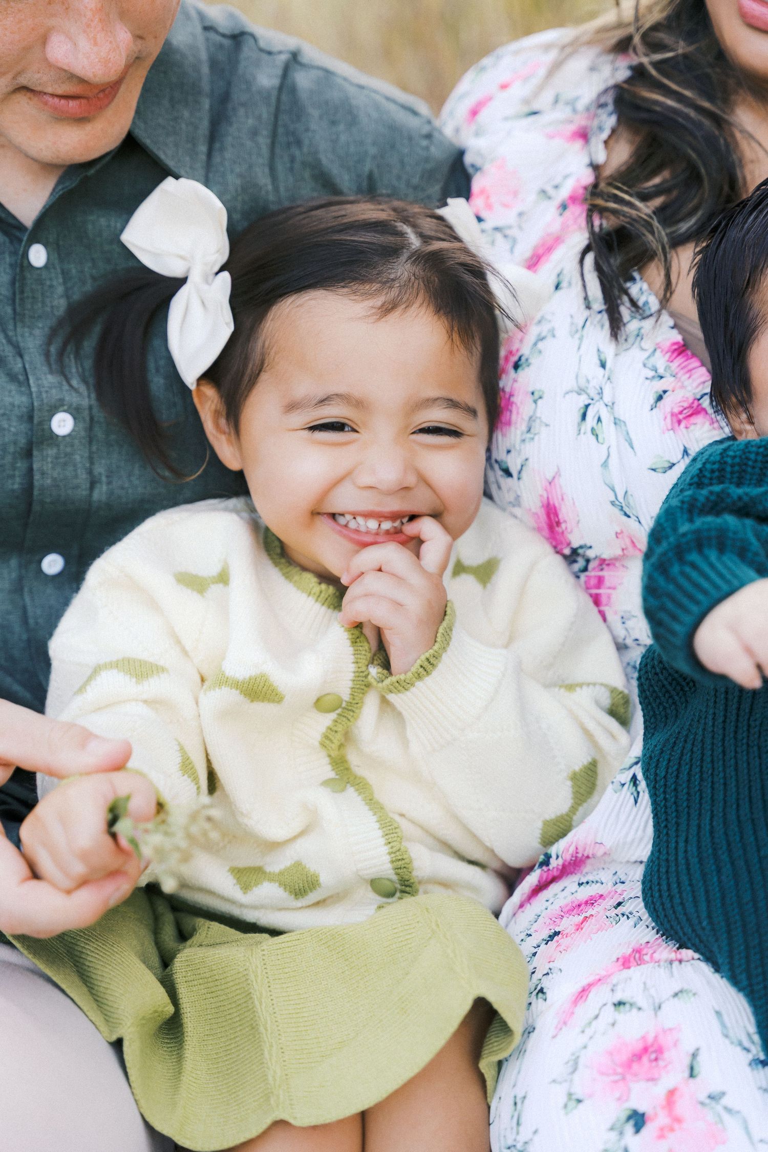 A young child wearing a light colored outfit smiles joyfully in a series of candid shots.
