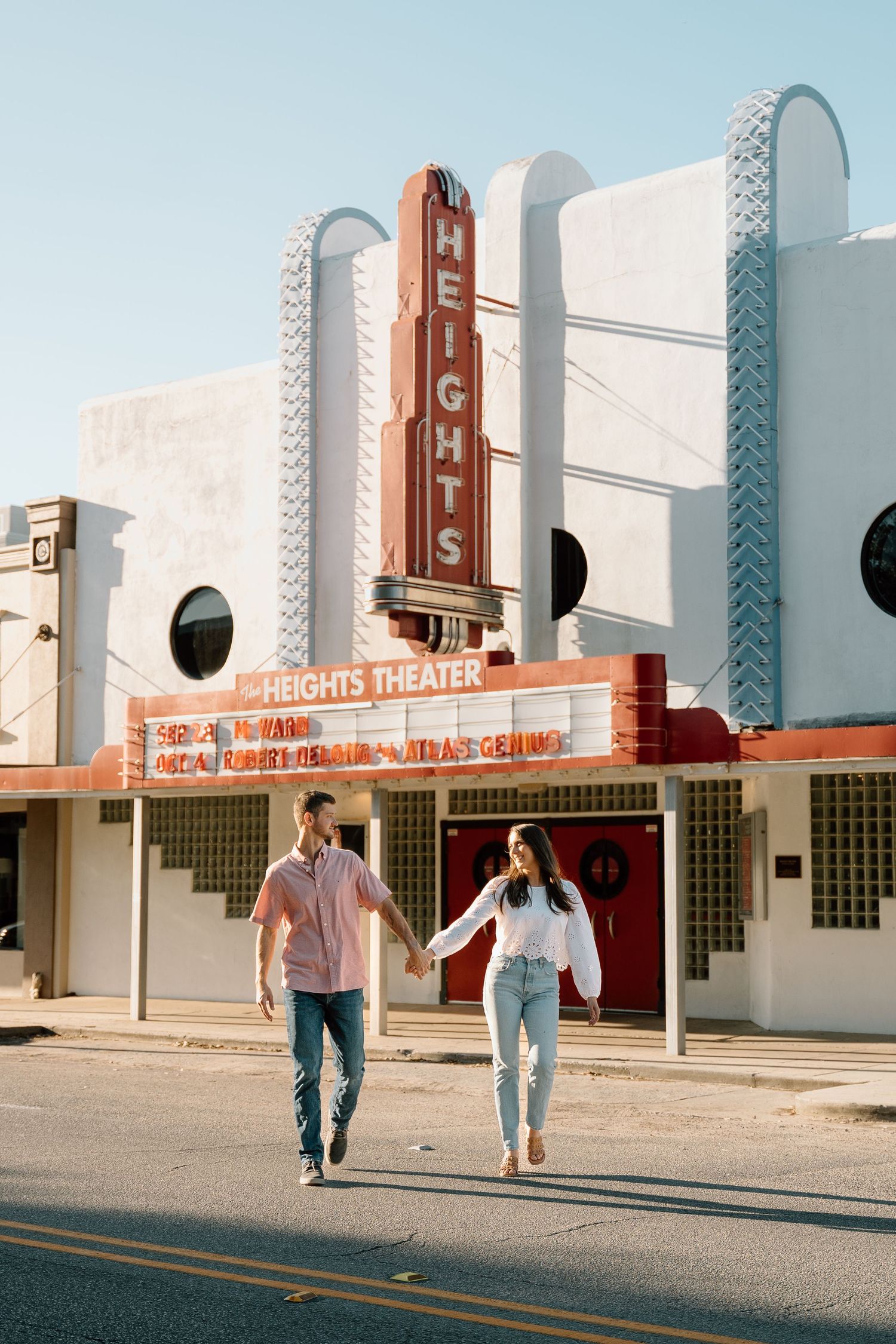 Sequence of people walking past a vintage art deco movie theater facade.