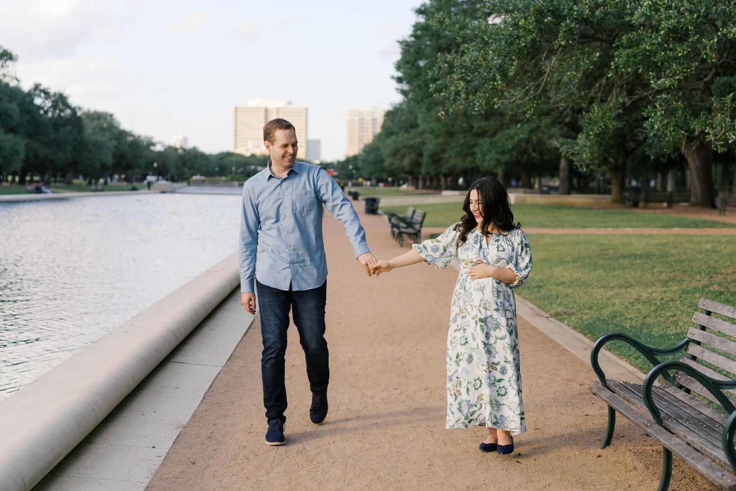 Family walking together along a peaceful waterfront path during golden hour.