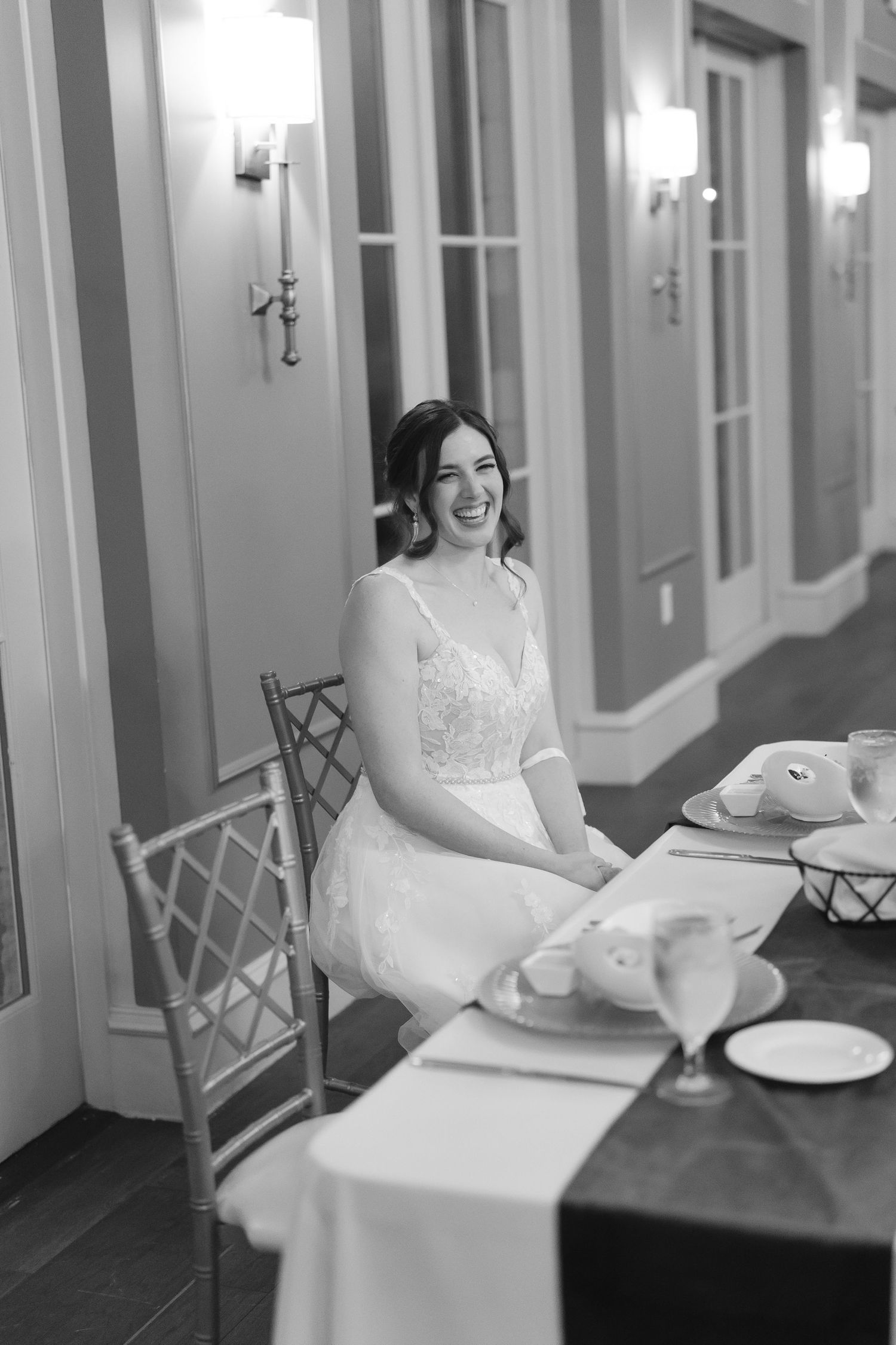 Black and white portrait in elegant hallway with classic wall sconces.