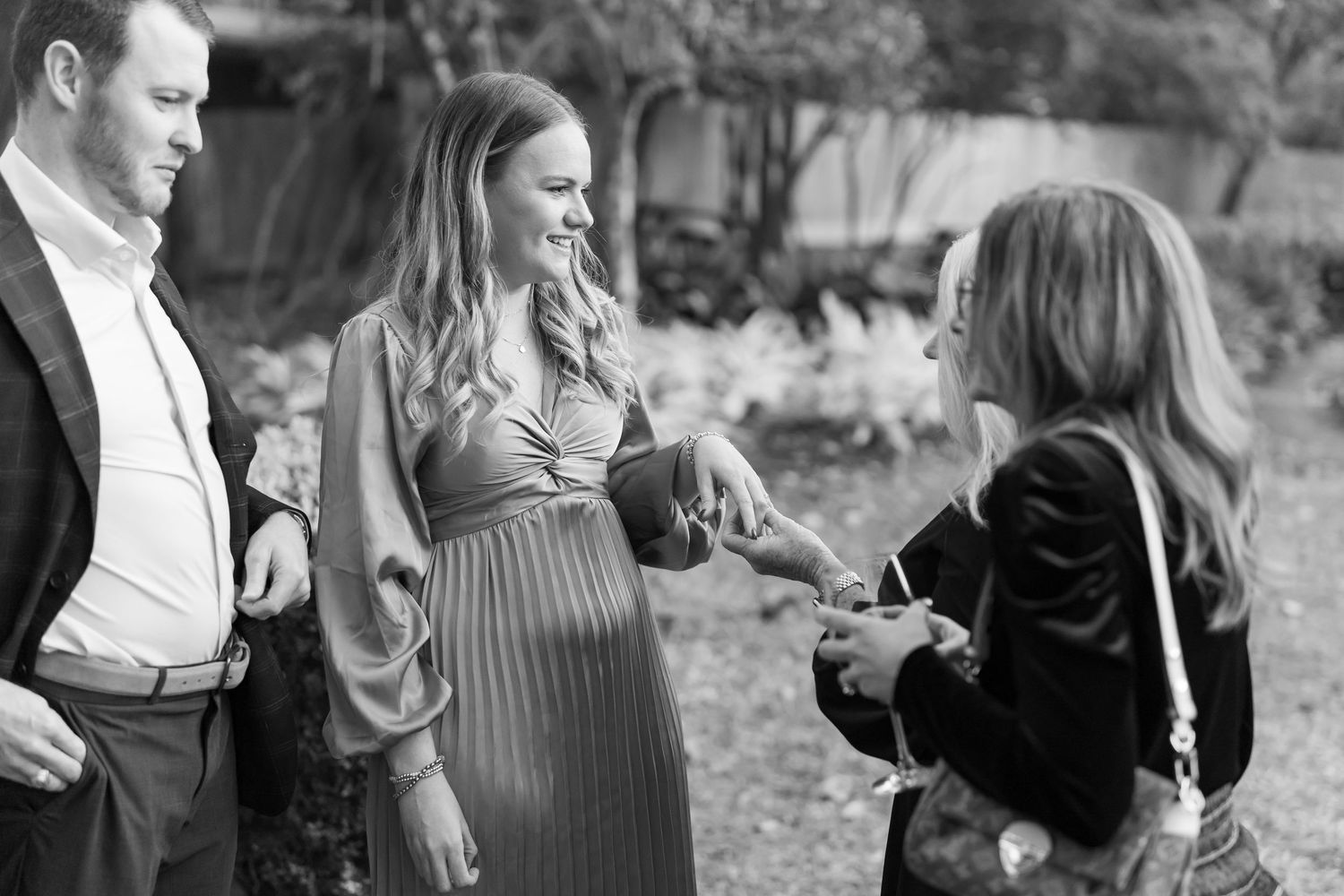 A casual outdoor gathering with people conversing in black and white photography.