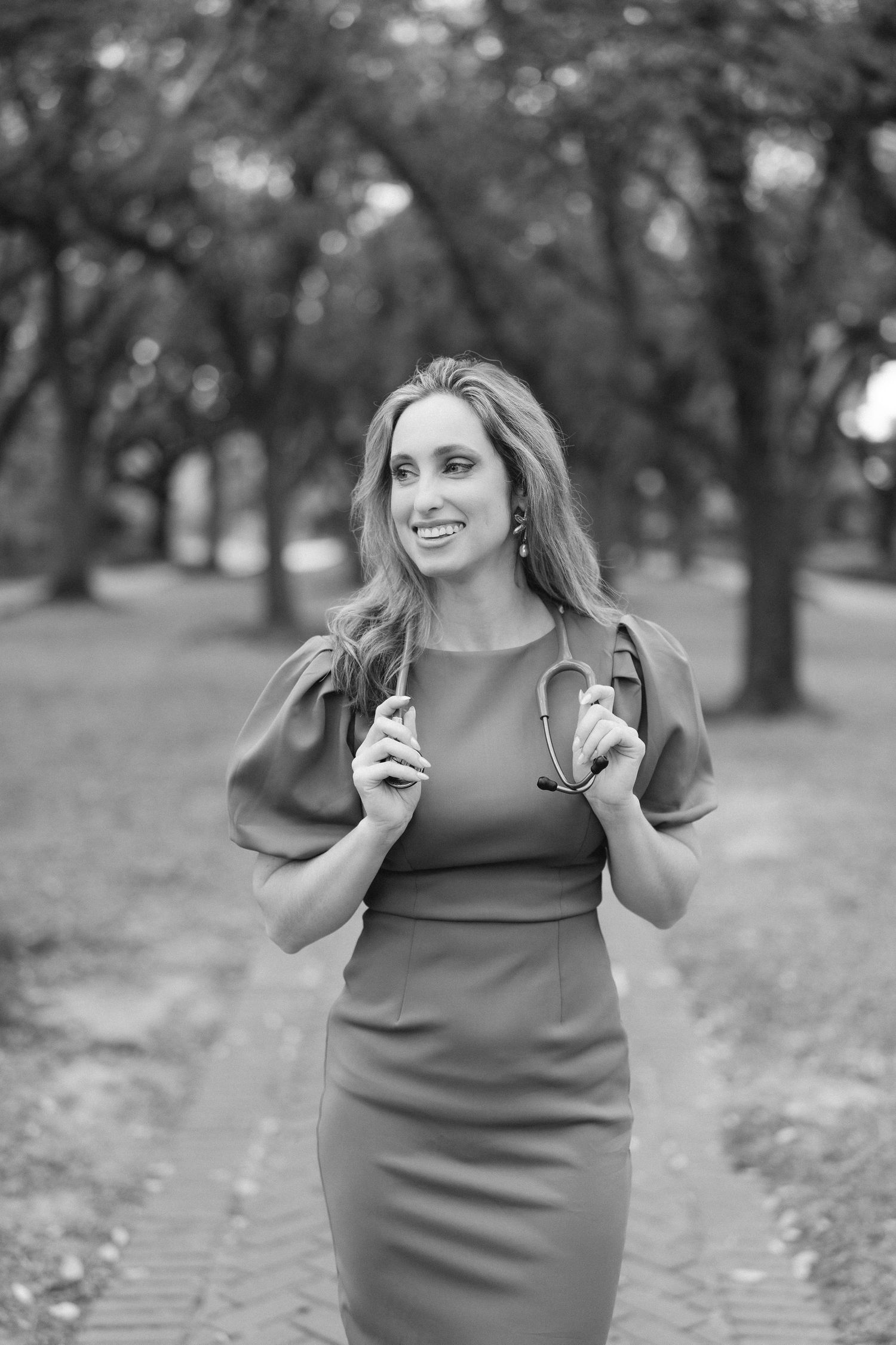 A joyful moment captured in black and white as someone dances beneath oak trees.