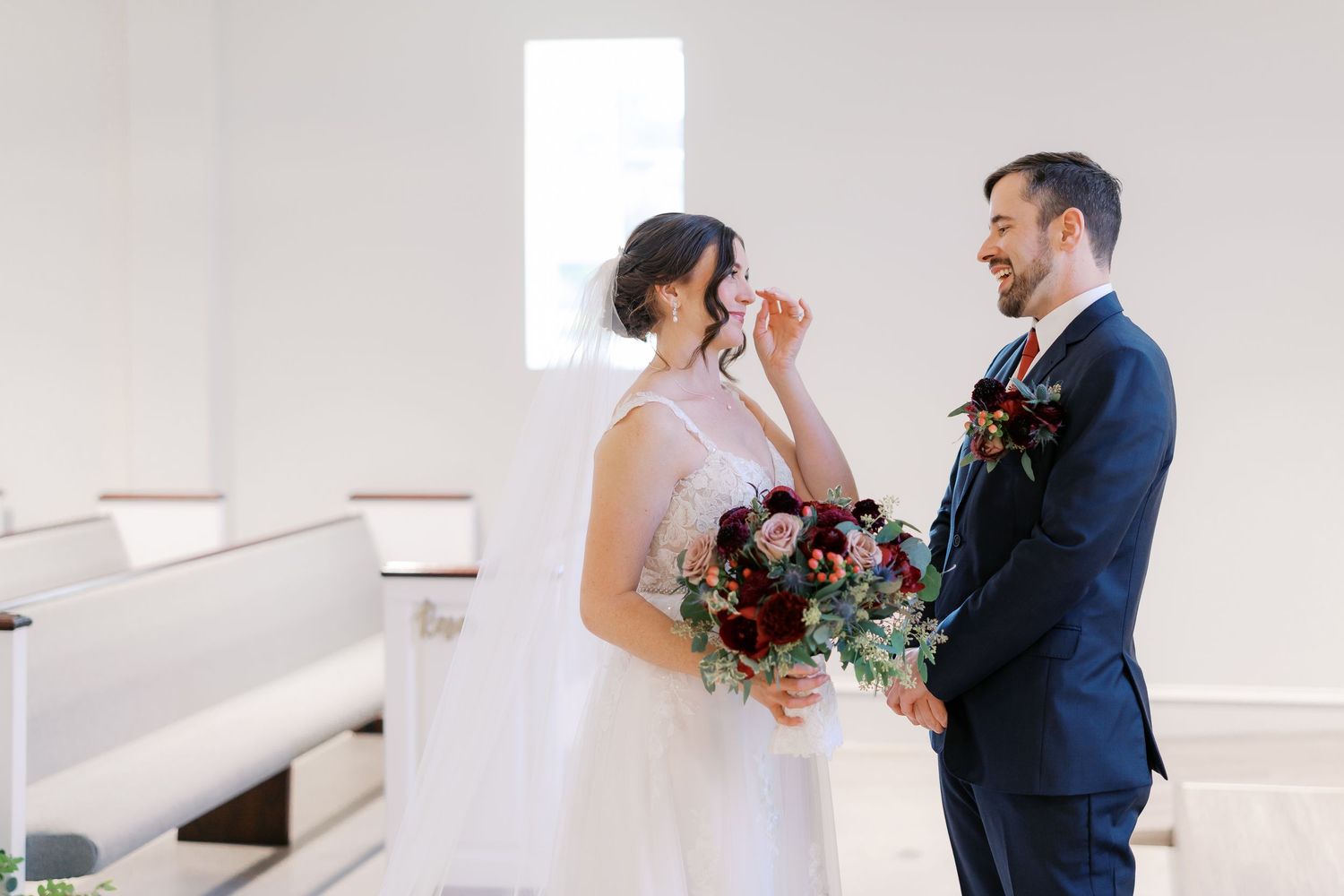 A joyful wedding moment captured in a bright white church interior.