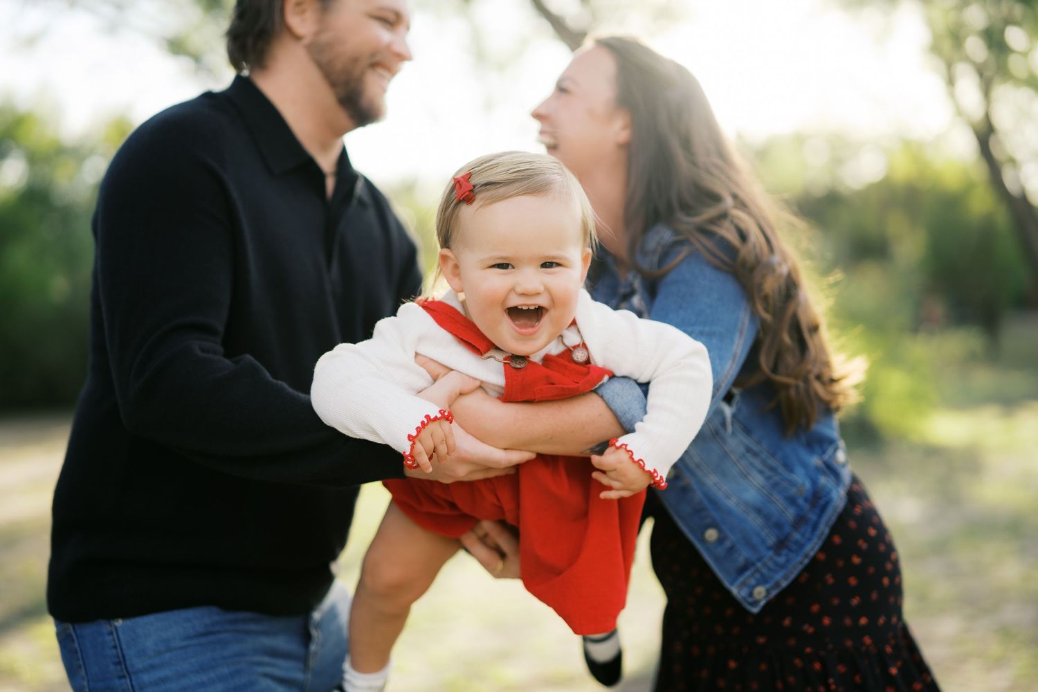 A family shares joyful moments together outdoors during a photo session.