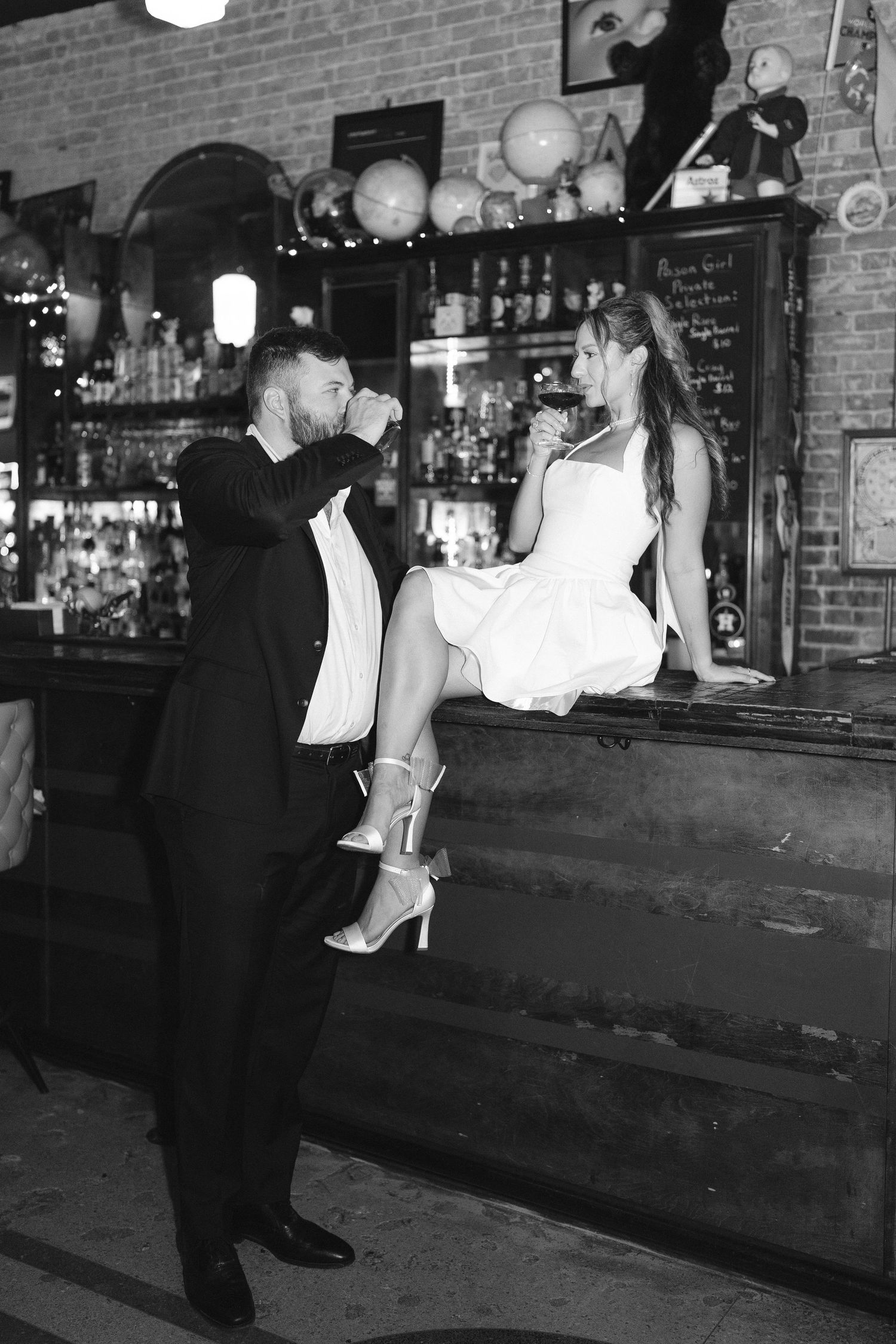 Artistic black and white capture of intimate moment at vintage bar setting.
