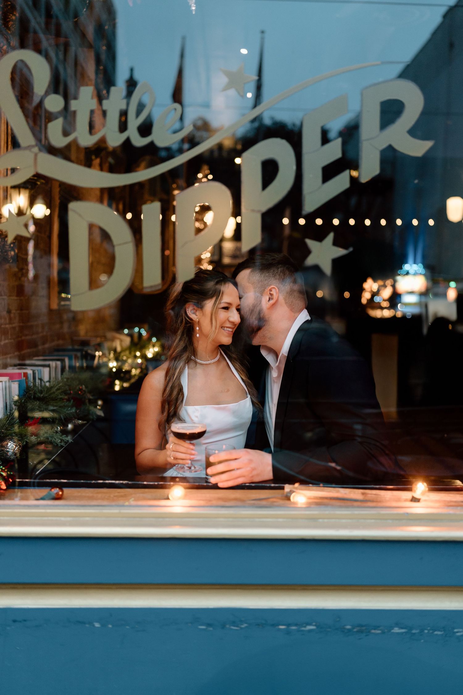 A romantic evening scene through a window with candlelight and soft lighting creating an intimate atmosphere.