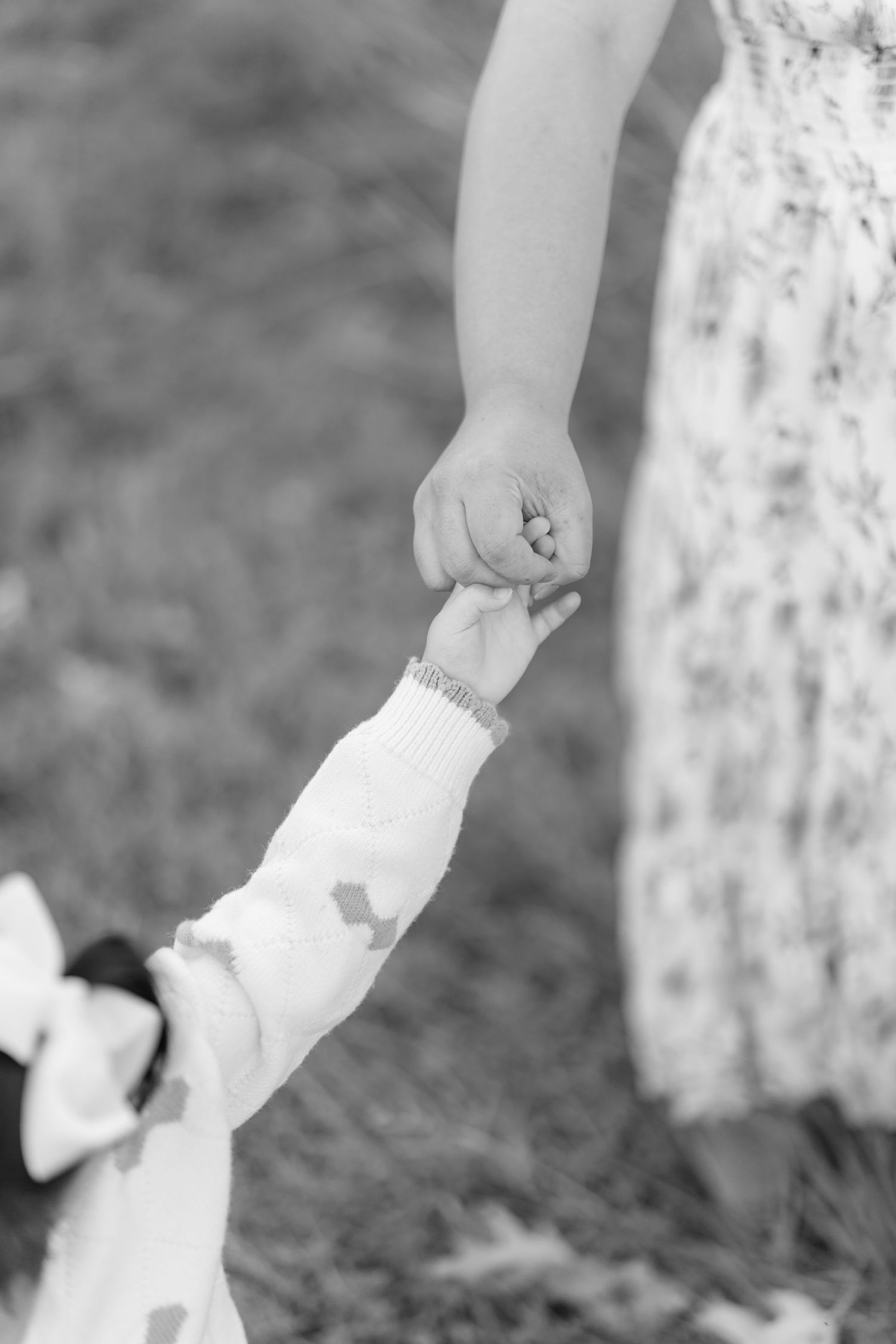 Black and white detail shots of hands against a floral dress background.