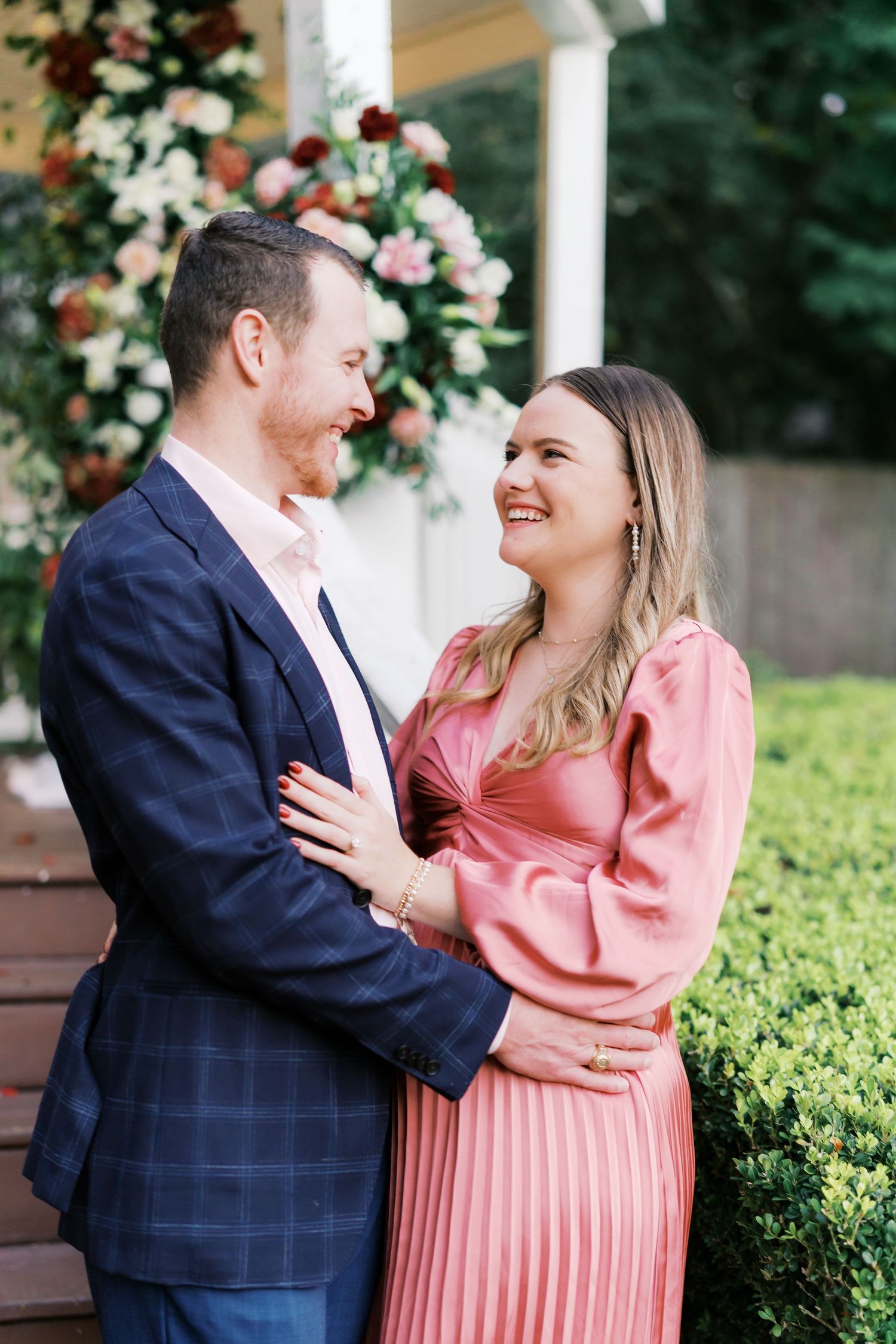 Couple sharing tender moments in a garden setting during their engagement.