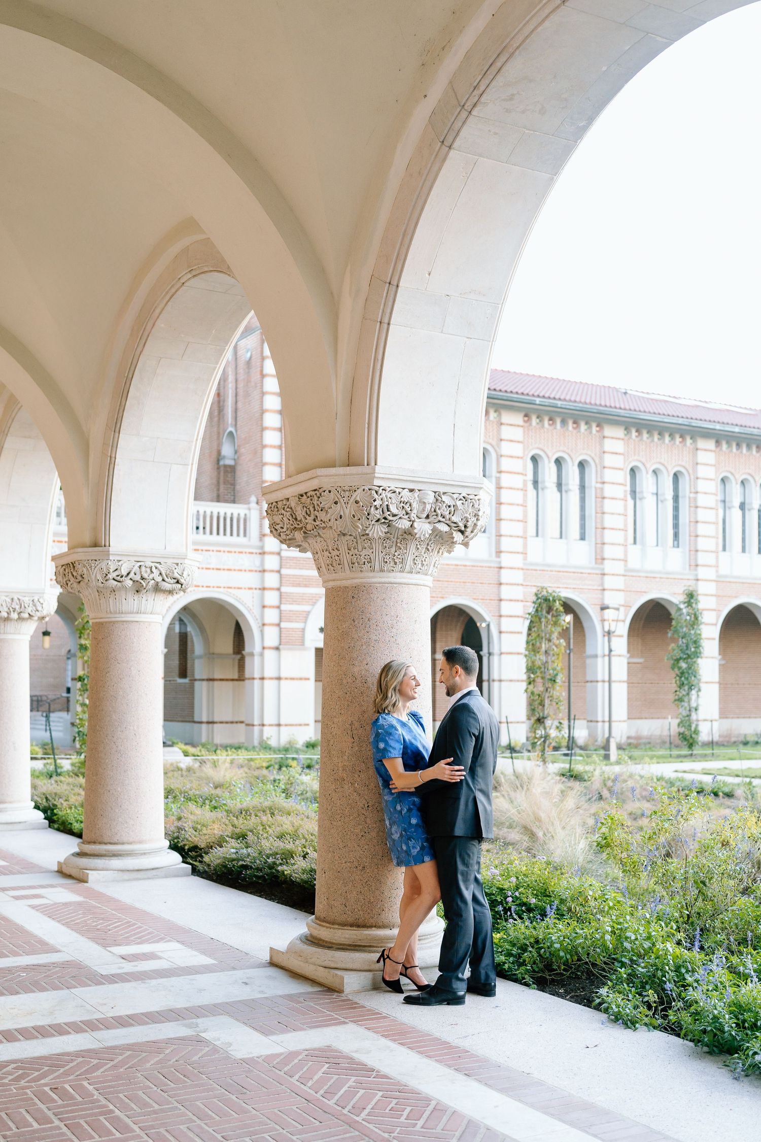 A romantic photoshoot under elegant white archways with ornate columns.