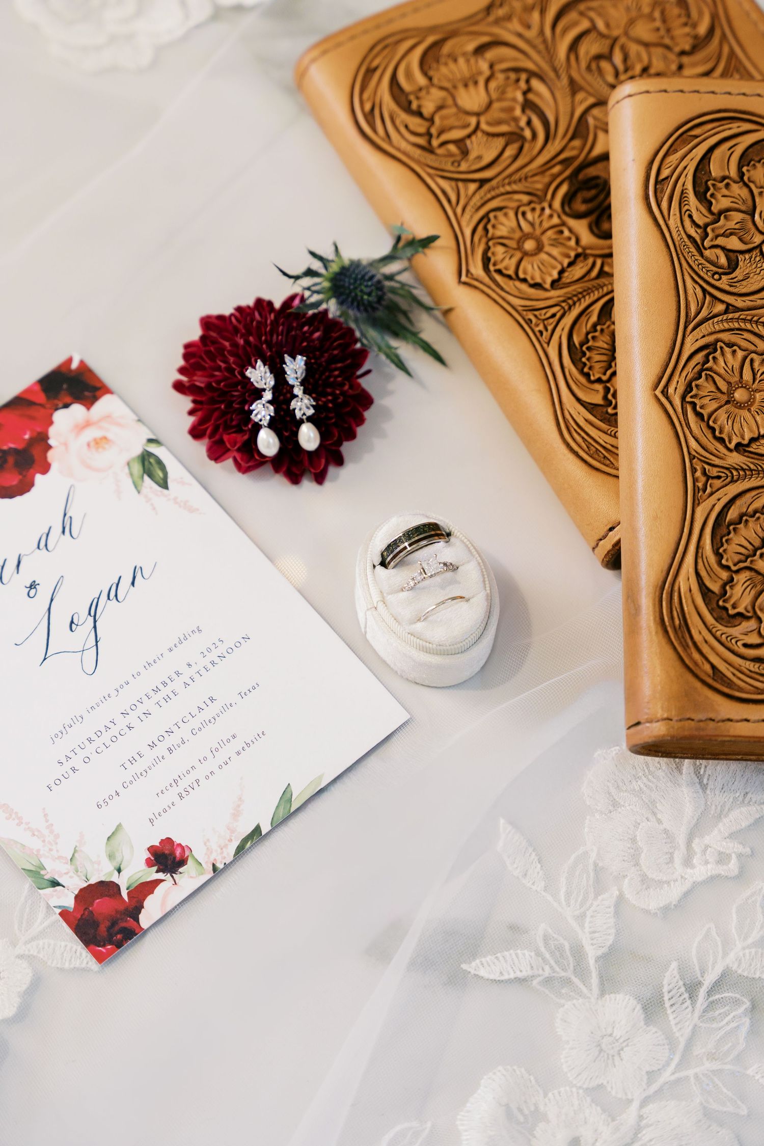 Wedding invitation suite with burgundy florals and elegant calligraphy on white paper.