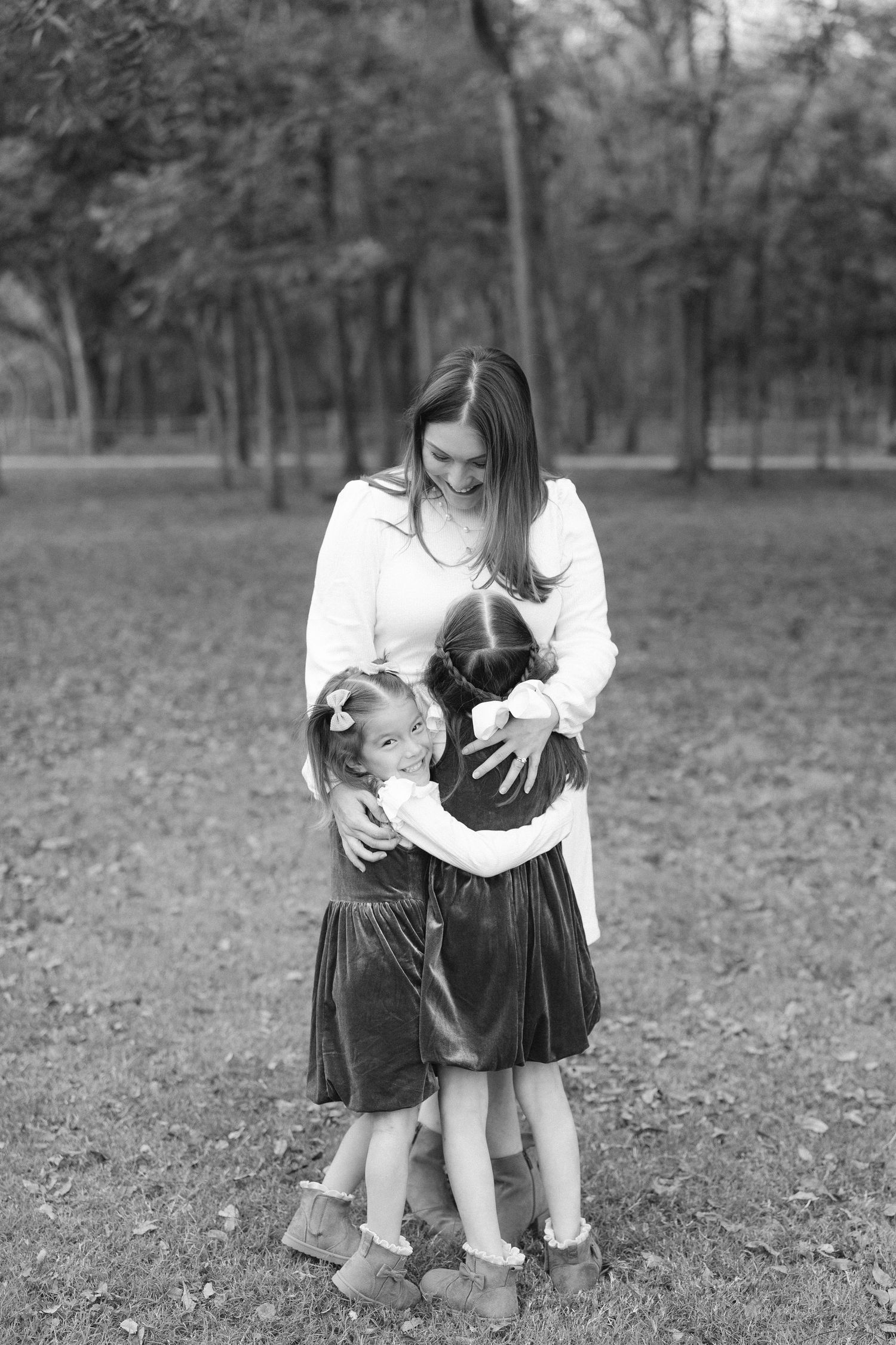 Black and white photo of tender family moments in a natural outdoor setting.