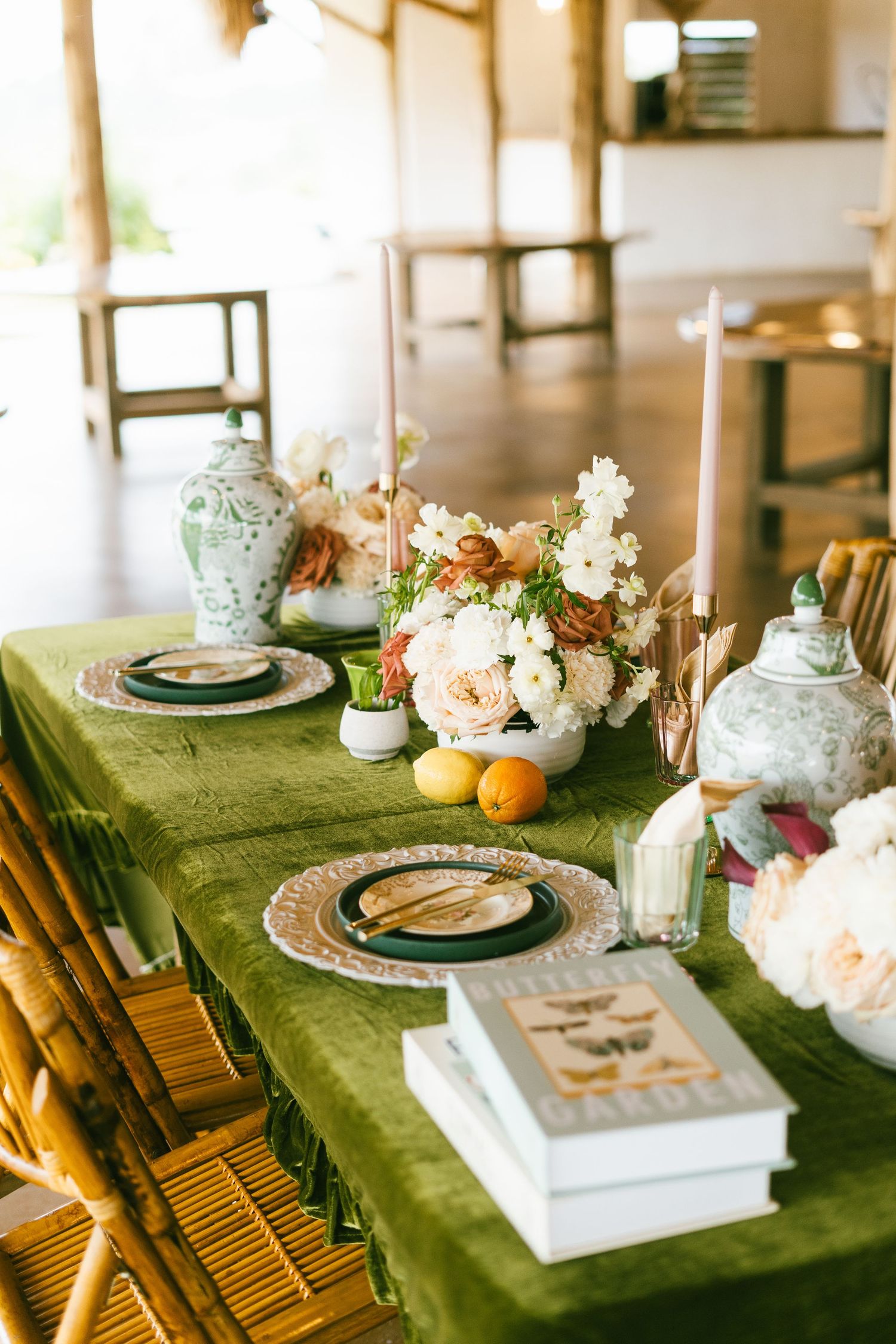 Elegant tablescape with green velvet cloth, vintage teapots and fresh floral arrangements.