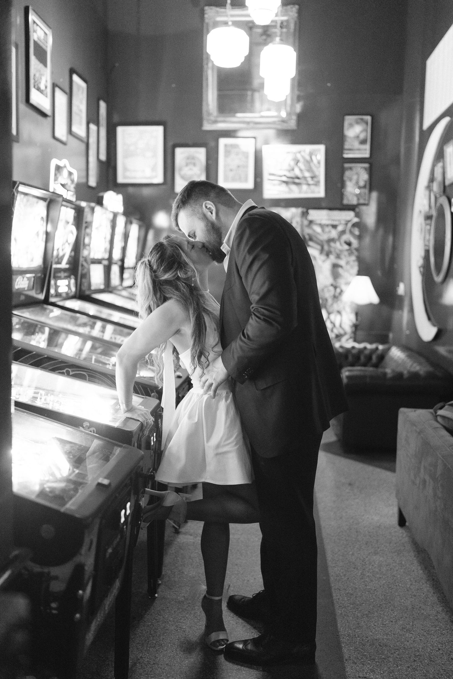Romantic black and white photos showing couple's intimate moments at retro arcade bar.