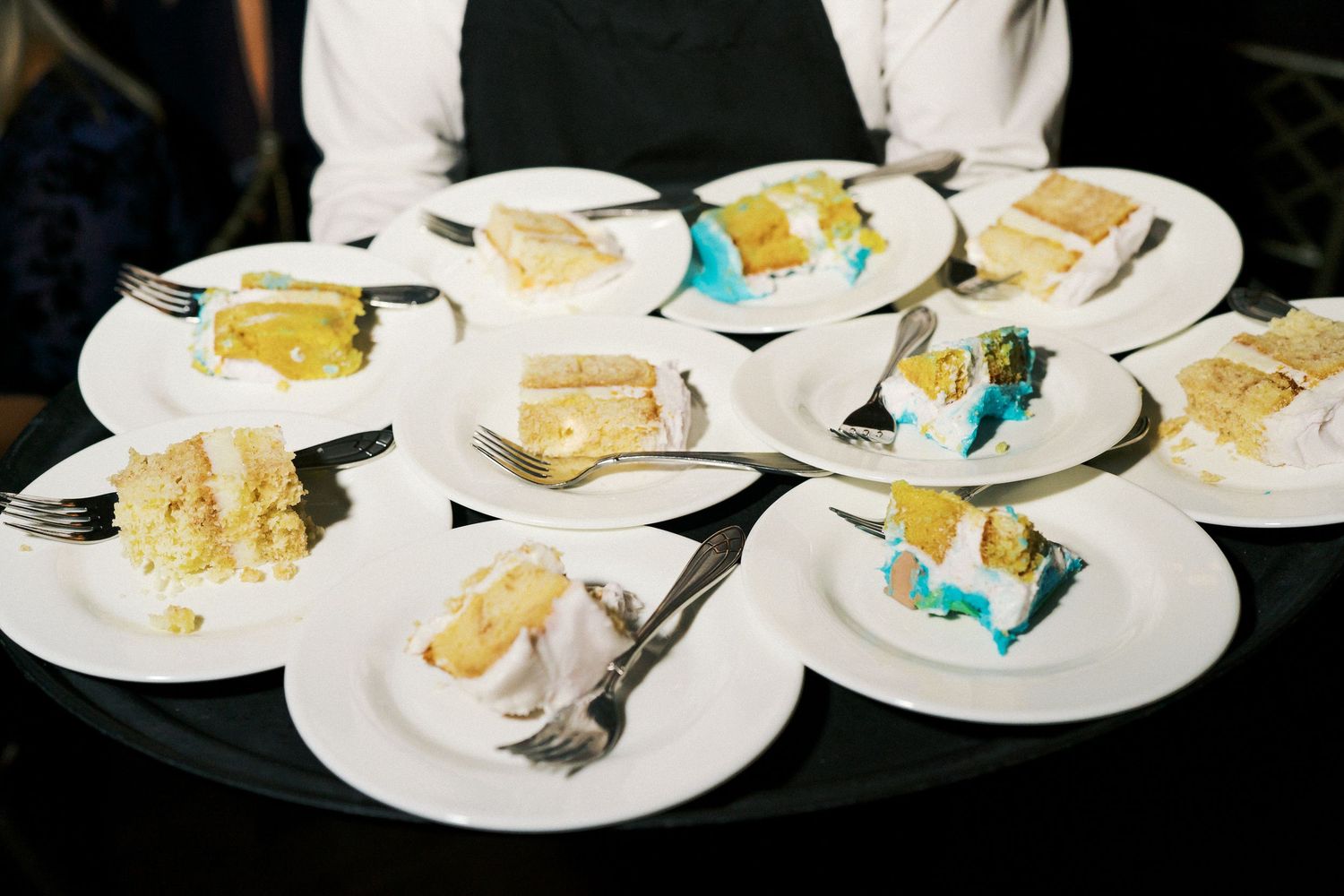 Multiple plates of wedding cake slices arranged on serving plates.