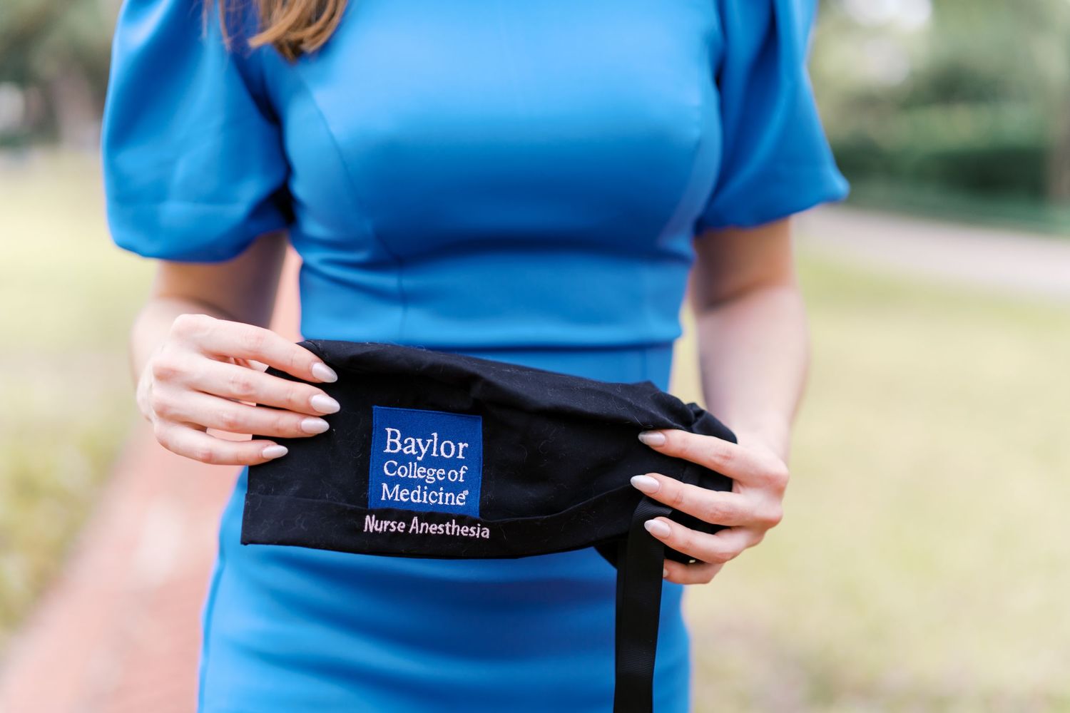 Close-up of a black support belt with branding details against a blue fabric background.